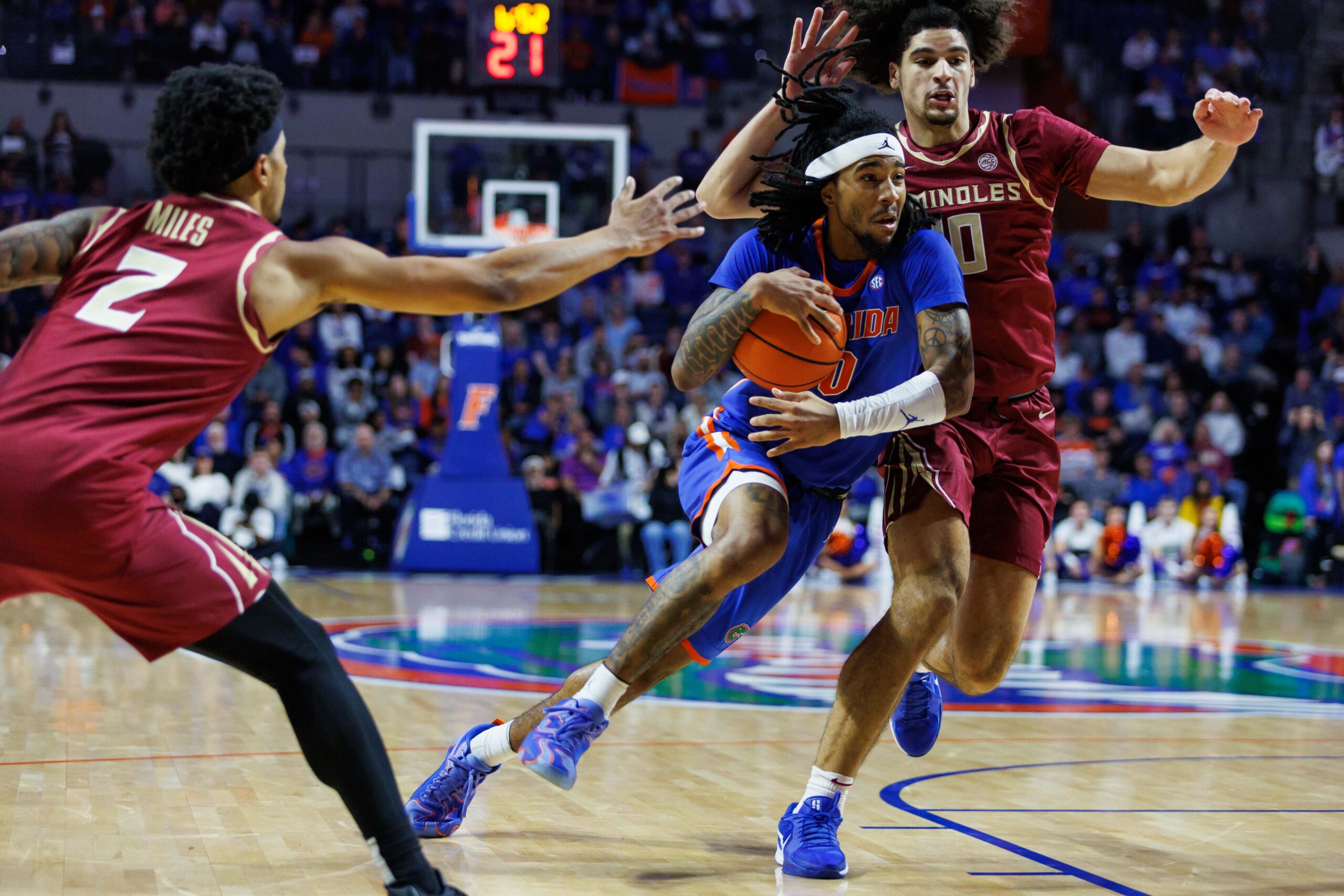 Nov 11, 2025; Gainesville, Florida, USA; Florida Gators guard Boogie Fland (0) dribbles the ball through Florida State Seminoles guard Lajae Jones (10) and guard Cam Miles (2) during the second half at Exactech Arena at the Stephen C. O'Connell Center. Mandatory Credit: Morgan Tencza-Imagn Images
