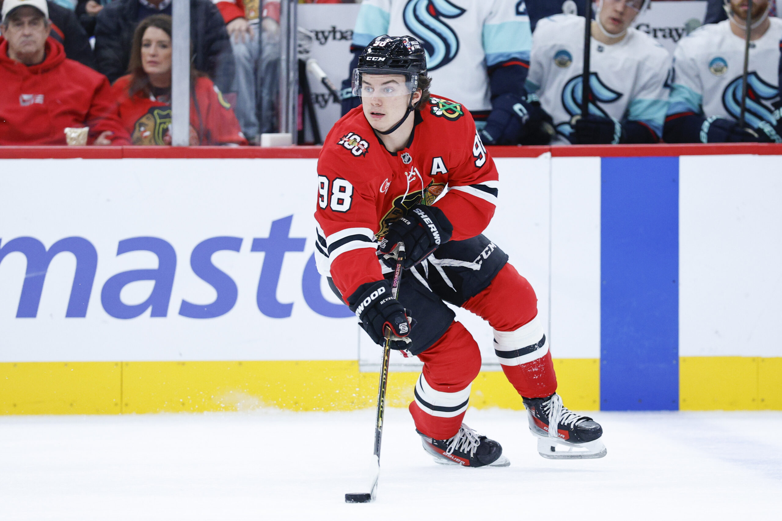 Nov 20, 2025; Chicago, Illinois, USA; Chicago Blackhawks center Connor Bedard (98) looks to pass the puck against the Seattle Kraken during the first period at United Center. Mandatory Credit: Kamil Krzaczynski-Imagn Images