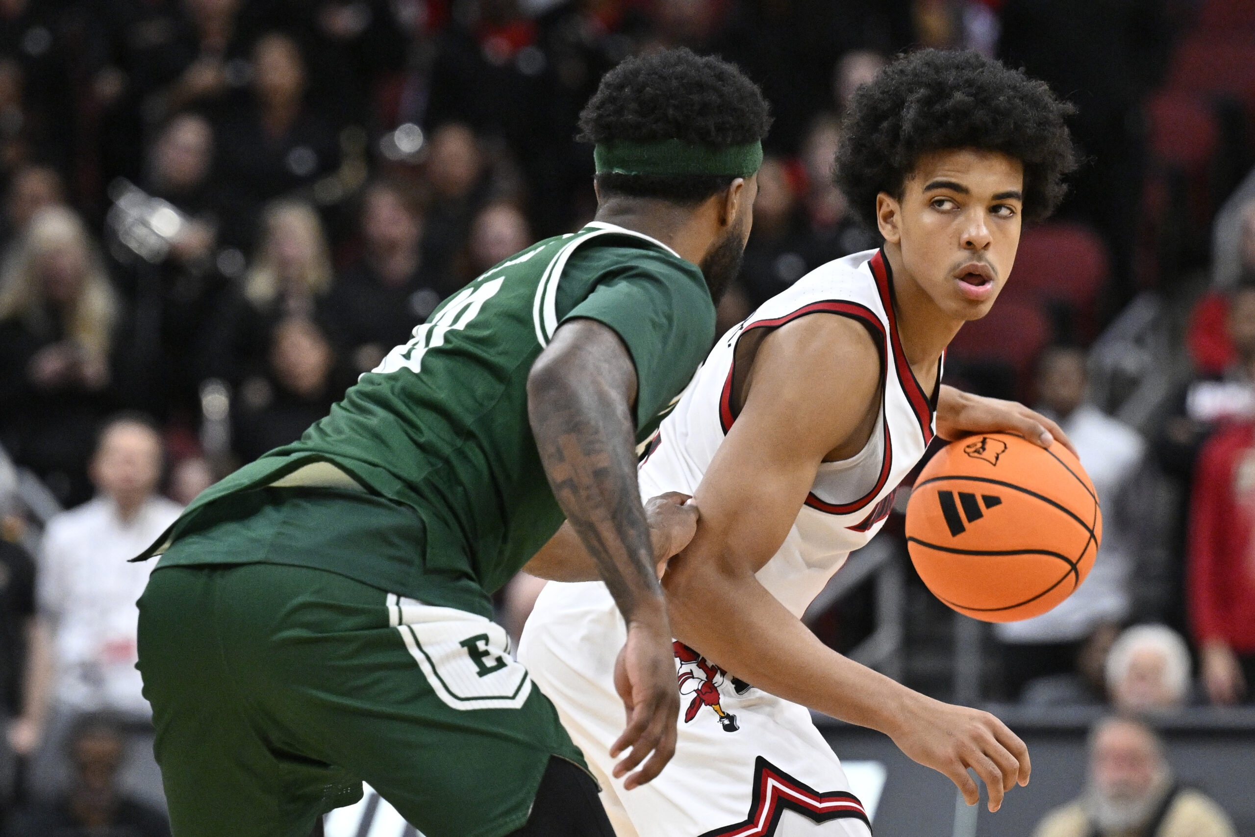 Nov 24, 2025; Louisville, Kentucky, USA;  Louisville Cardinals guard Mikel Brown Jr. (0) dribbles against Eastern Michigan Eagles guard Jon Sanders (10) during the second half at KFC Yum! Center. Louisville defeated Eastern Michigan 87-46. Mandatory Credit: Jamie Rhodes-Imagn Images