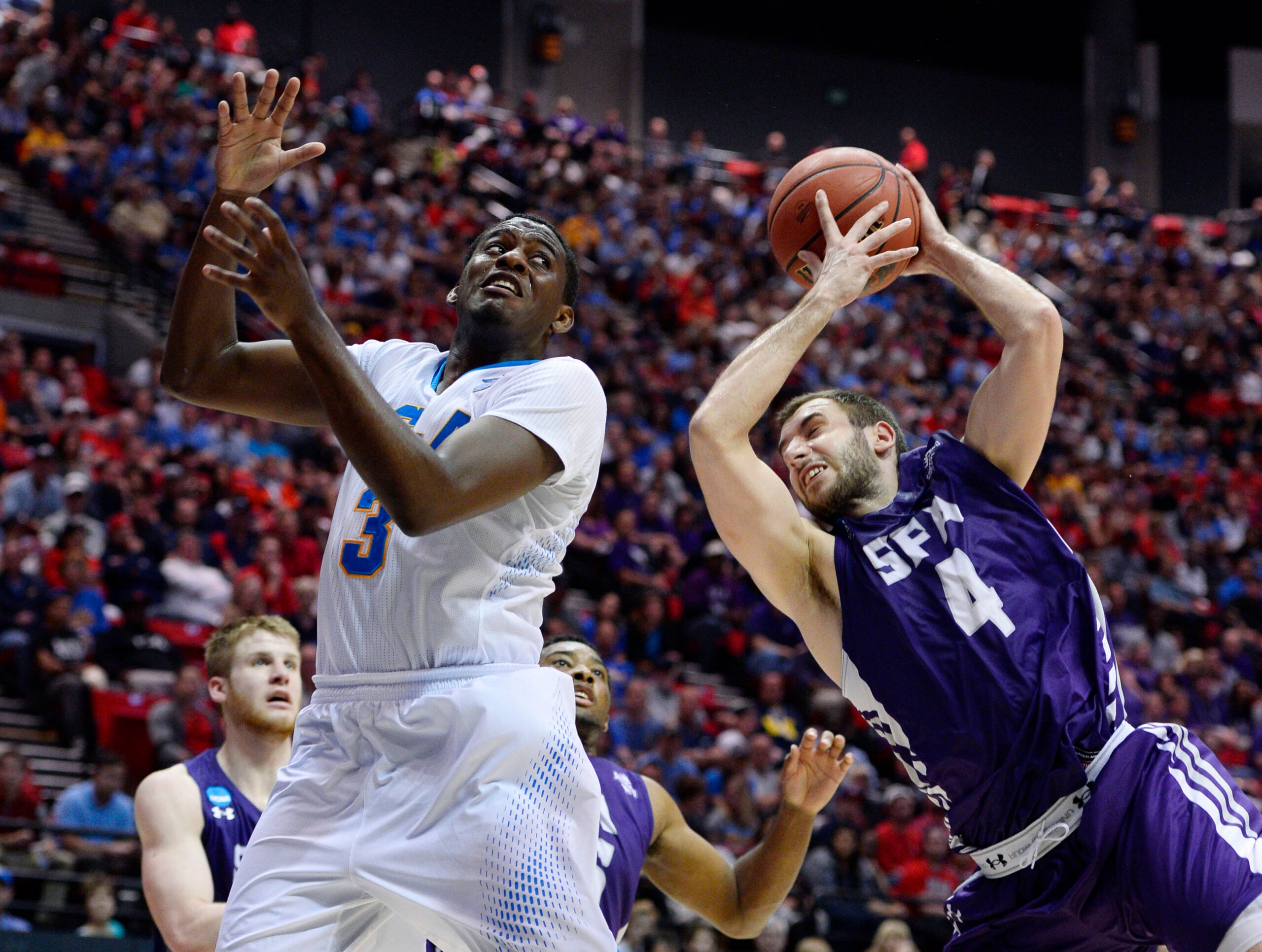 Mar 23, 2014; San Diego, CA, USA; UCLA Bruins guard Jordan Adams (3) battles for a rebound with Stephen F. Austin Lumberjacks forward Nikola Gajic (4) in the second half of a men's college basketball game during the third round of the 2014 NCAA Tournament at Viejas Arena. Mandatory Credit: Christopher Hanewinckel-Imagn Images