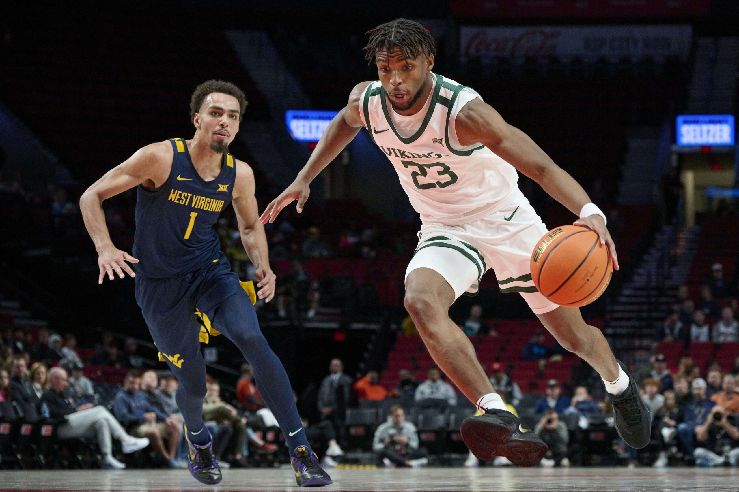 Nov 25, 2022; Portland, Oregon, USA; Portland State Vikings guard Jorell Saterfield (23) drives to the basket past West Virginia Mountaineers forward Emmitt Matthews Jr. (1) during the first half at Moda Center. Mandatory Credit: Troy Wayrynen-Imagn Images