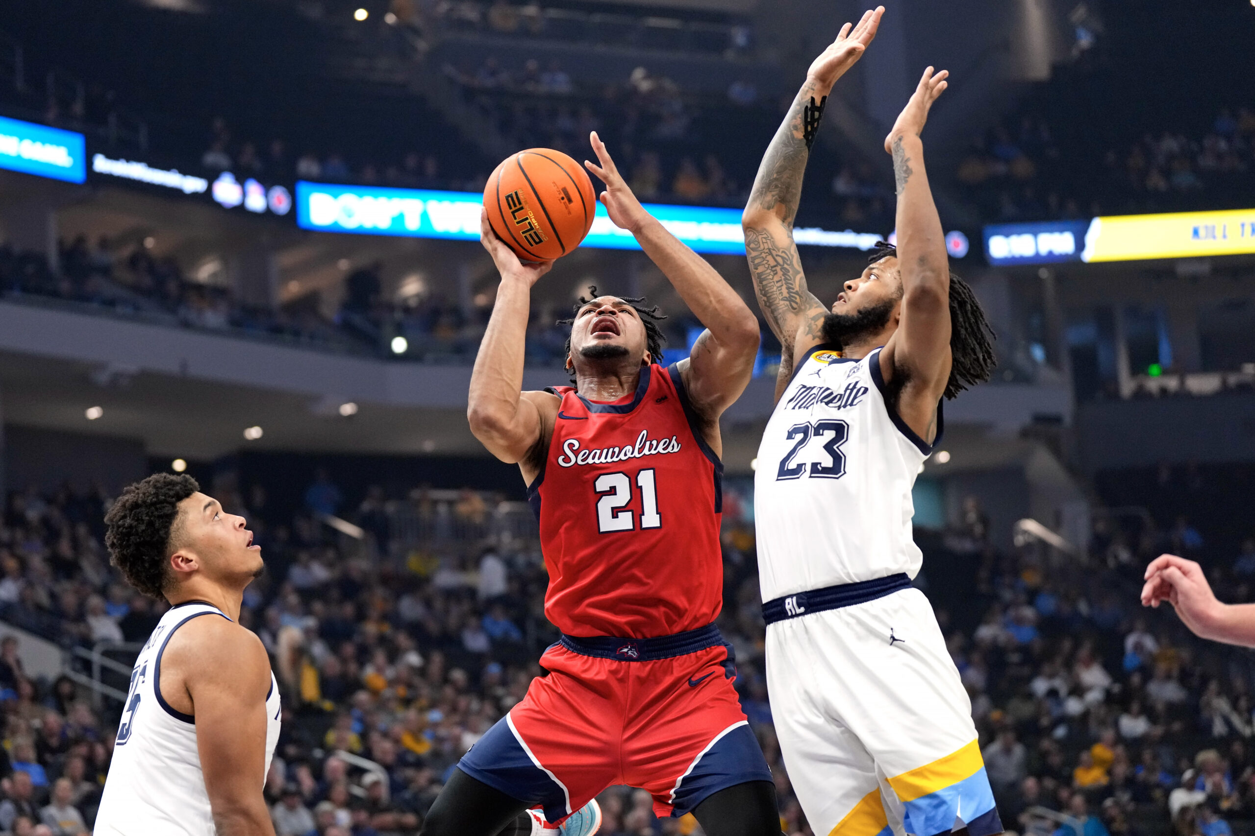 Nov 4, 2024; Milwaukee, Wisconsin, USA;  Stony Brook Seawolves guard-forward Andre Snoddy (21) shoots around Marquette Golden Eagles forward David Joplin (23) during the first half at Fiserv Forum. Mandatory Credit: Jeff Hanisch-Imagn Images