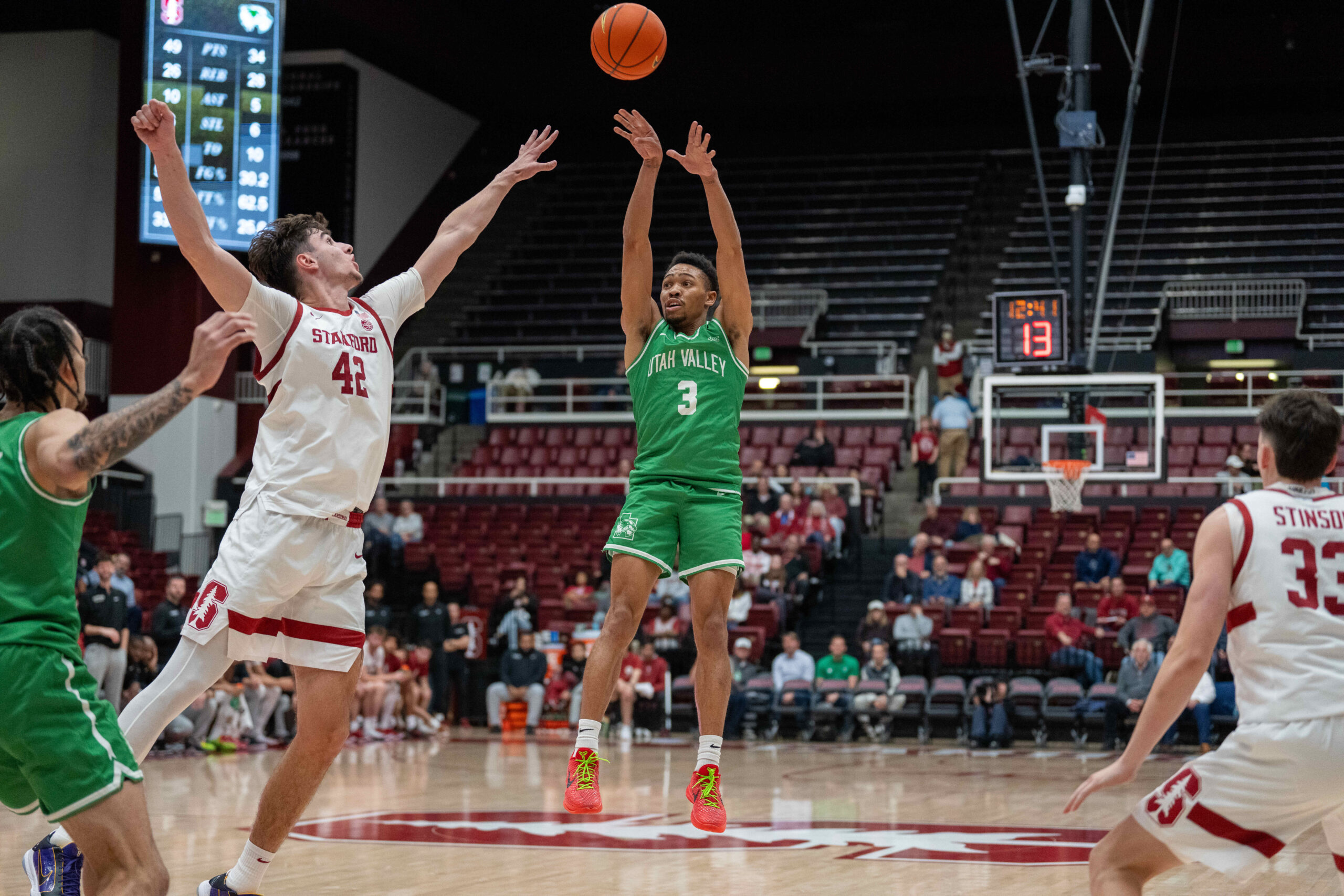 Dec 3, 2024; Stanford, California, USA; Utah Valley Wolverines guard Kylin Green (3) shoots a three point shot agonist Stanford Cardinal forward Maxime Raynaud (42) during the second half at Maples Pavilion. Mandatory Credit: Neville E. Guard-Imagn Images