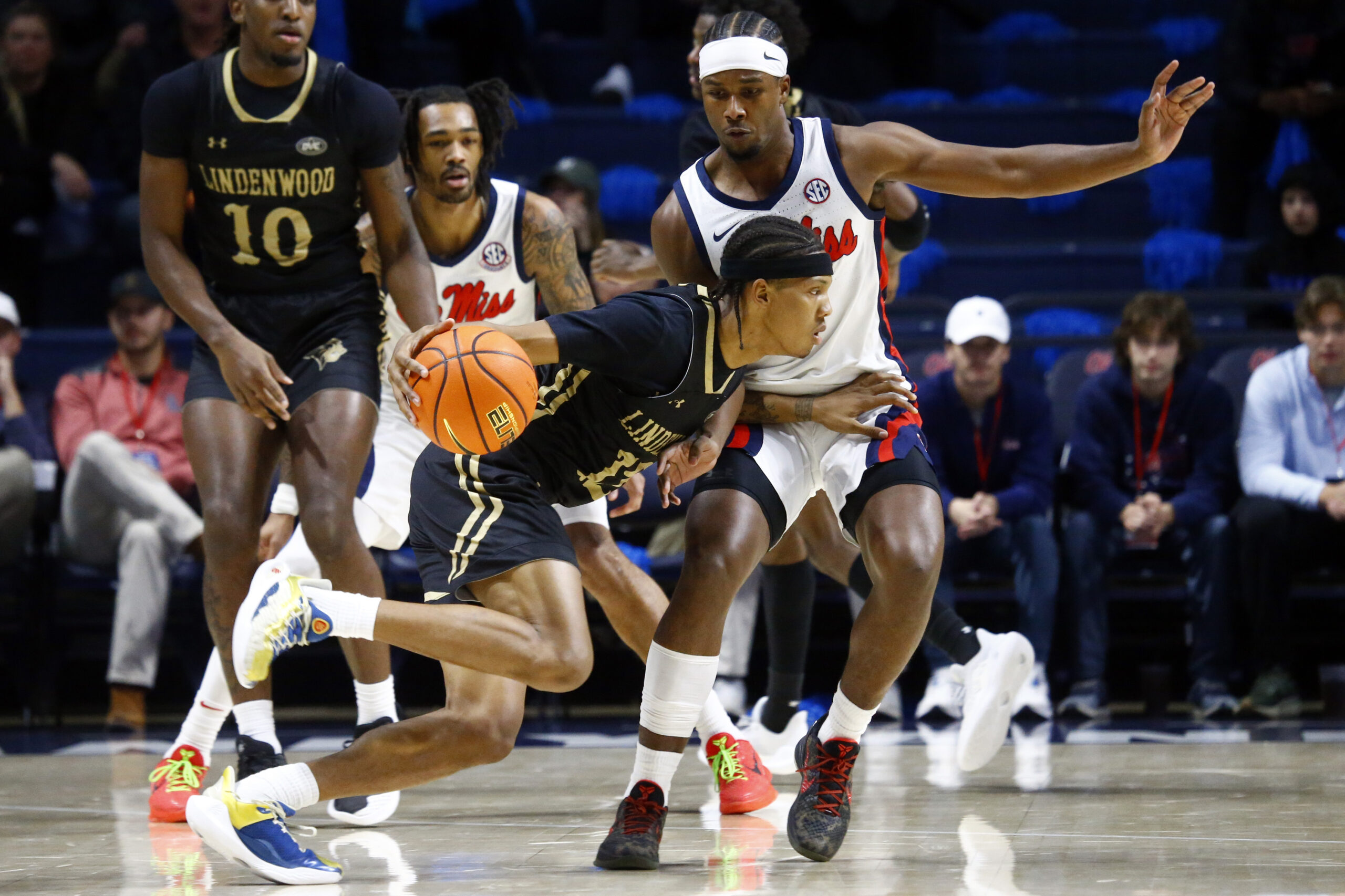 Dec 7, 2024; Oxford, Mississippi, USA; Lindenwood Lions guard Anias Futrell (12) dribbles the ball against Mississippi Rebels guard Davon Barnes (7) during the first half at The Sandy and John Black Pavilion at Ole Miss. Mandatory Credit: Petre Thomas-Imagn Images
