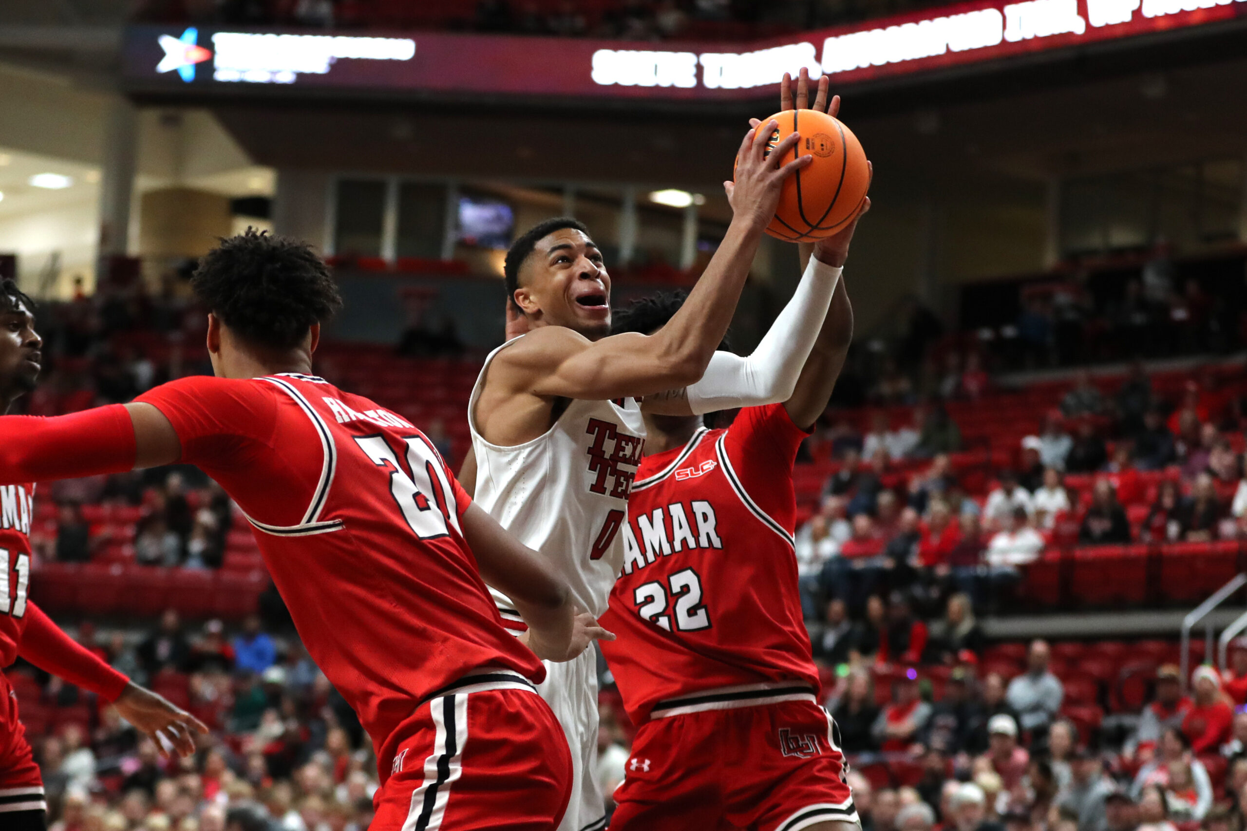 Dec 21, 2024; Lubbock, Texas, USA; Texas Tech Red Raiders guard Chance McMillian (0) reacts going to the basket against Lamar Cardinals forward Andrew Holifield (22) in the first half at United Supermarkets Arena. Mandatory Credit: Michael C. Johnson-Imagn Images