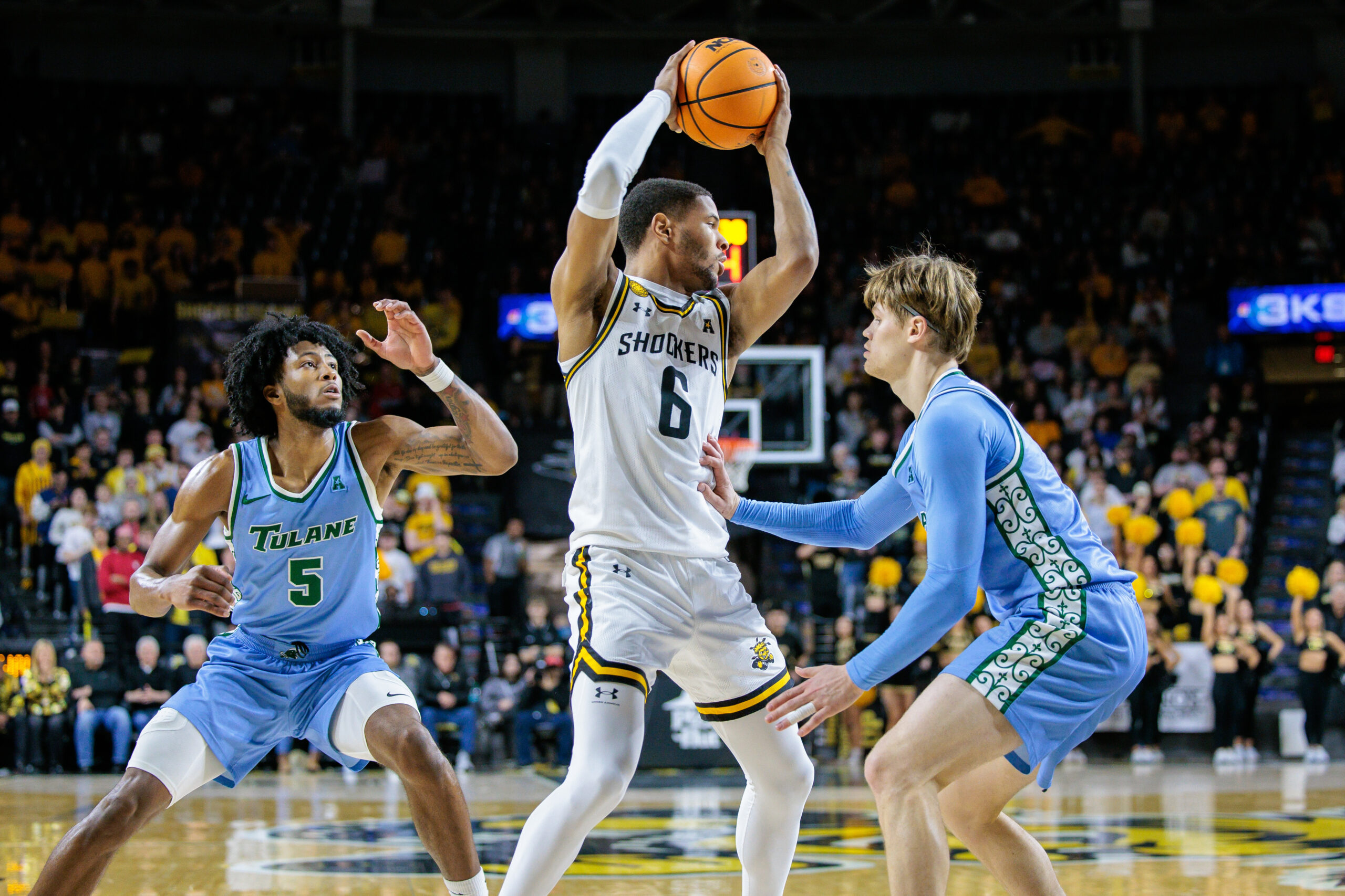 Feb 23, 2025; Wichita, Kansas, USA; Wichita State Shockers forward Corey Washington (6) looks to pass over Tulane Green Wave guard Rowan Brumbaugh (7) during the second half at Charles Koch Arena. Mandatory Credit: William Purnell-Imagn Images
