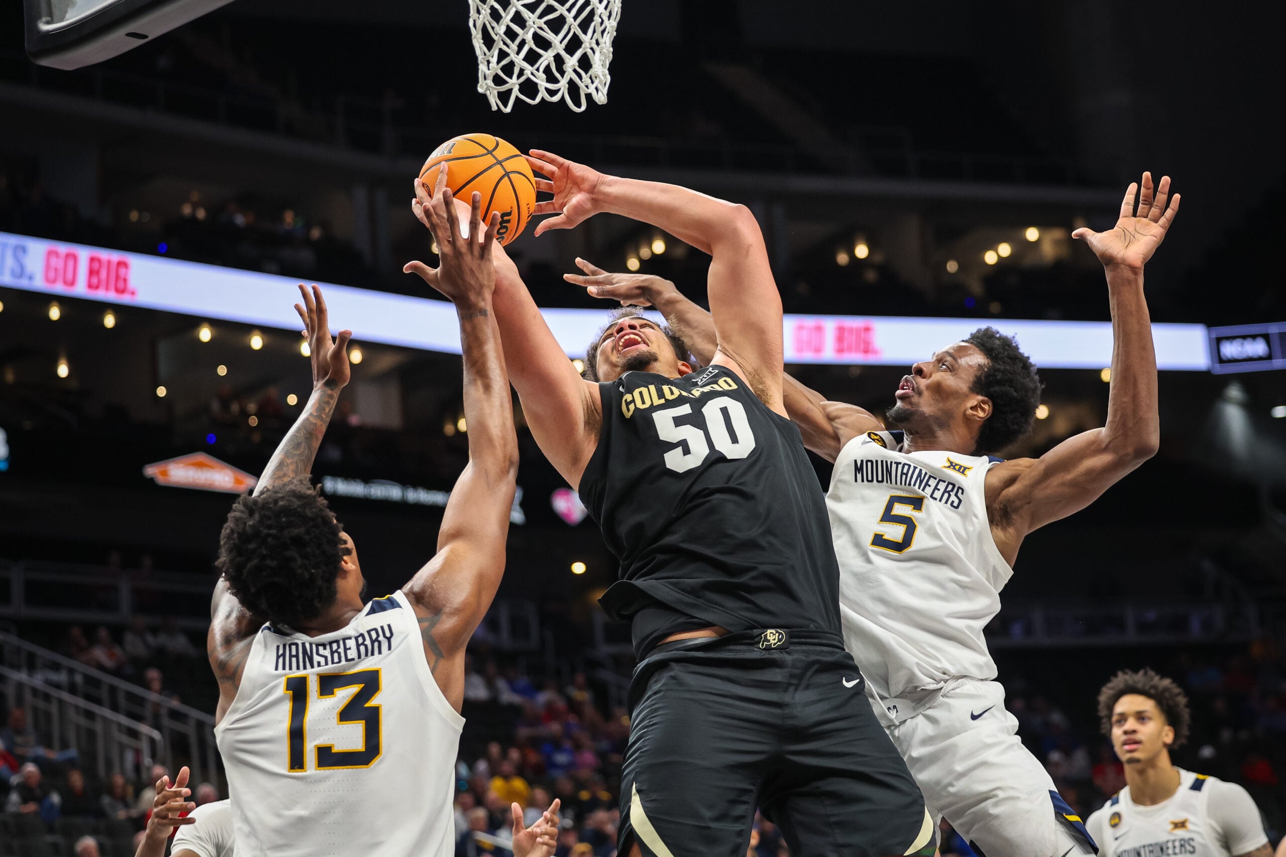 Mar 12, 2025; Kansas City, MO, USA; Colorado Buffaloes center Elijah Malone (50) shoots the ball around West Virginia Mountaineers guard Toby Okani (5) and West Virginia Mountaineers forward Amani Hansberry (13) during the second half at T-Mobile Center. Mandatory Credit: William Purnell-Imagn Images