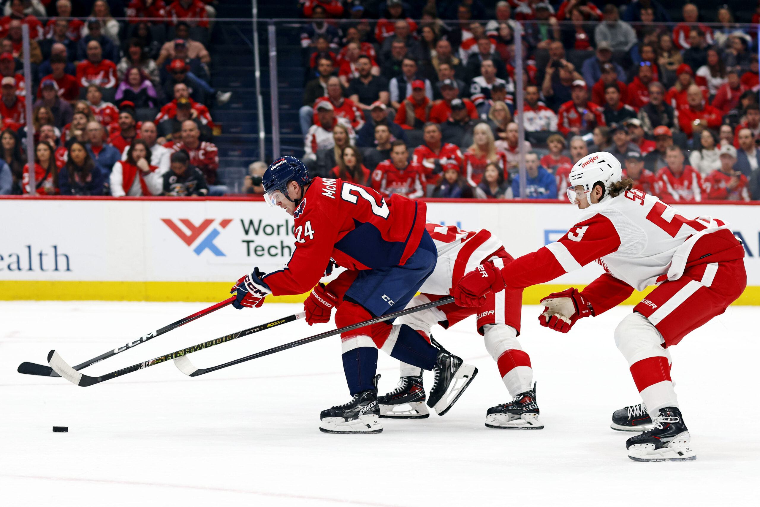 Mar 18, 2025; Washington, District of Columbia, USA; Washington Capitals center Connor McMichael (24) moves the puck against Detroit Red Wings defenseman Moritz Seider (53) during the first period at Capital One Arena. Mandatory Credit: Peter Casey-Imagn Images