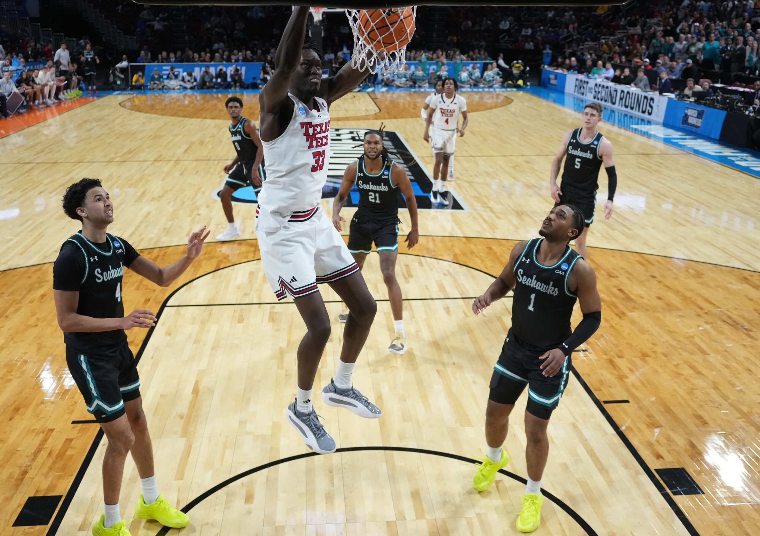 Mar 20, 2025; Wichita, KS, USA; Texas Tech Red Raiders forward Federiko Federiko (33) dunks against North Carolina-Wilmington Seahawks guard Nolan Hodge (4) and guard Donovan Newby (1) in the second half of a first round men’s NCAA Tournament game at Intrust Bank Arena. Mandatory Credit: Kirby Lee-Imagn Images