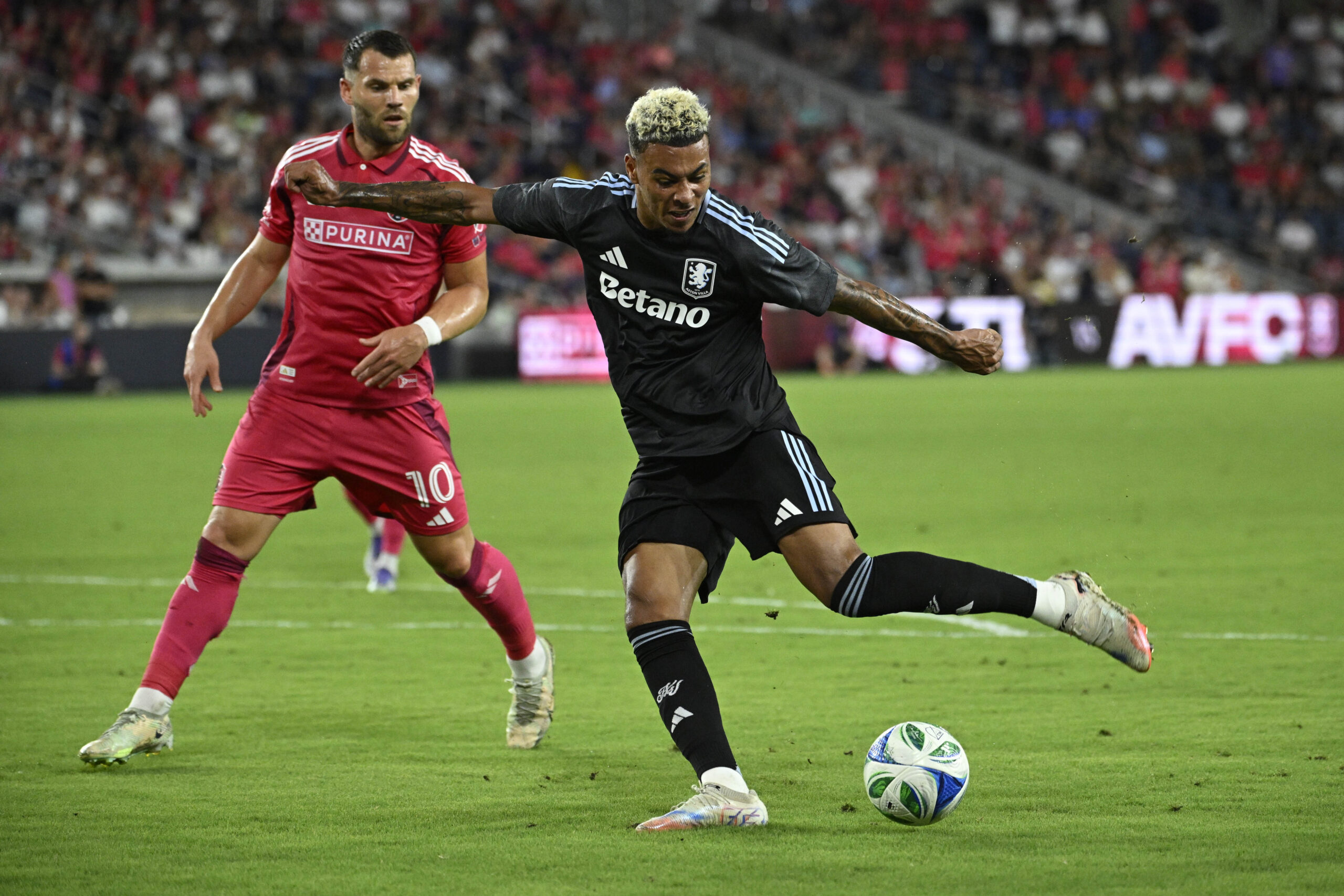 Jul 30, 2025; St. Louis, Missouri, USA; St. Louis City midfielder Eduard Lowen (10) pressures Aston Villa midfielder Morgan Rogers (27) as he takes a shot in the first half at Energizer Park. Mandatory Credit: Joe Puetz-Imagn Images