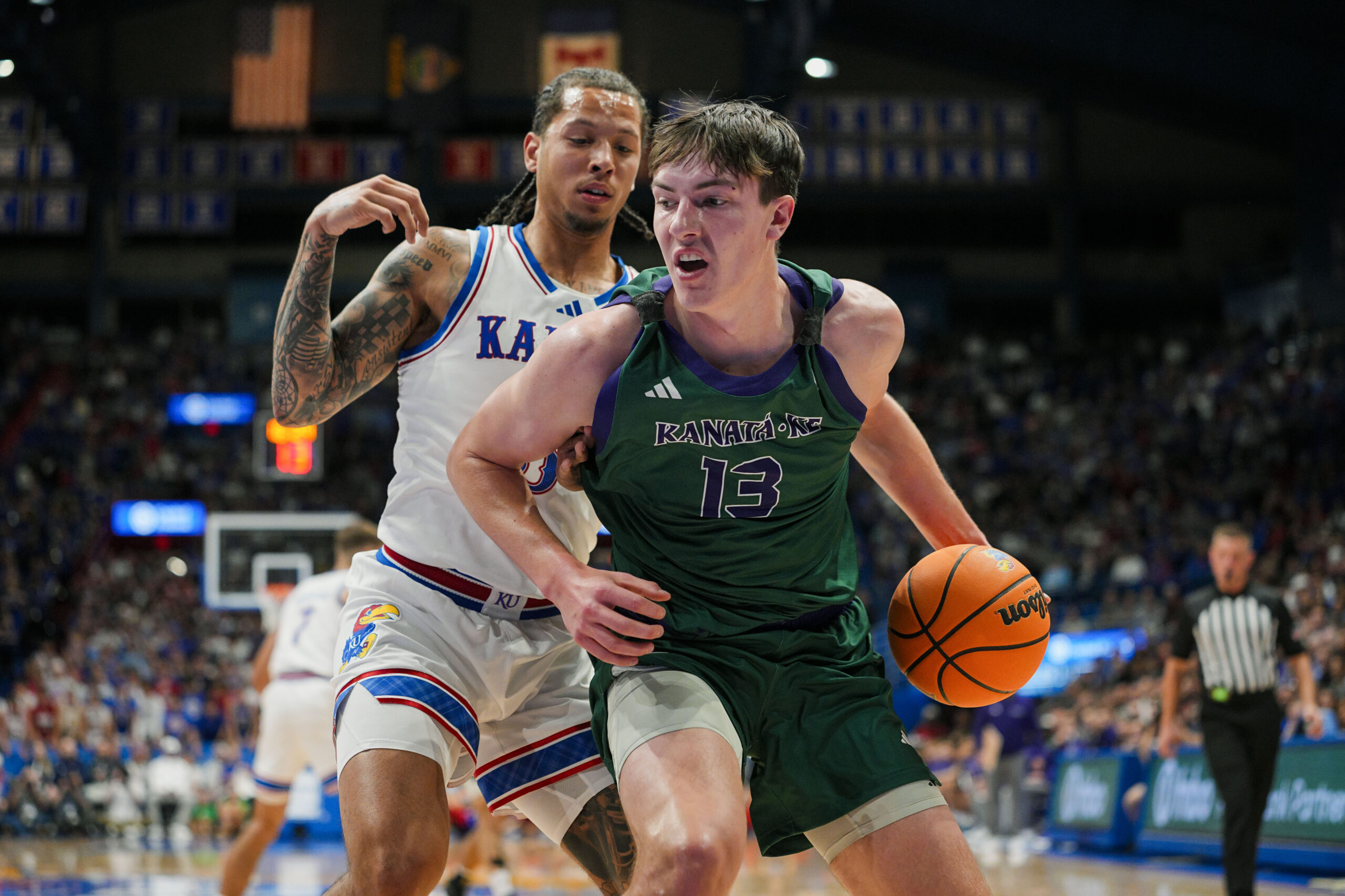 Nov 3, 2025; Lawrence, Kansas, USA; Green Bay Phoenix forward Marcus Hall (13) drives against Kansas Jayhawks guard Tre White (3) during the first half at Allen Fieldhouse. Mandatory Credit: Jay Biggerstaff-Imagn Images