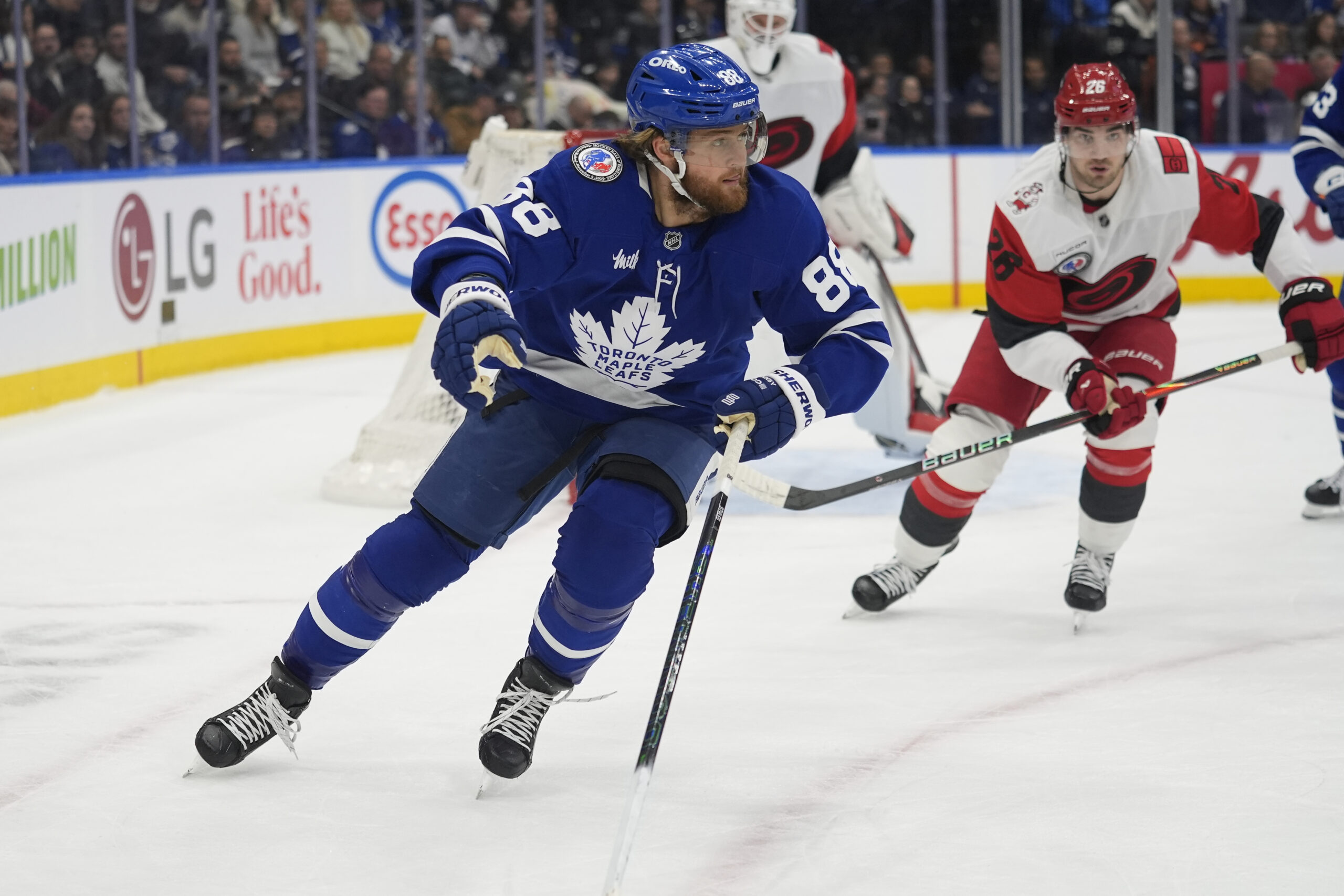 Nov 9, 2025; Toronto, Ontario, CAN; Toronto Maple Leafs forward William Nylander (88) and Carolina Hurricanes defenseman Sean Walker (26) chase after a puck during the first period at Scotiabank Arena. Mandatory Credit: John E. Sokolowski-Imagn Images