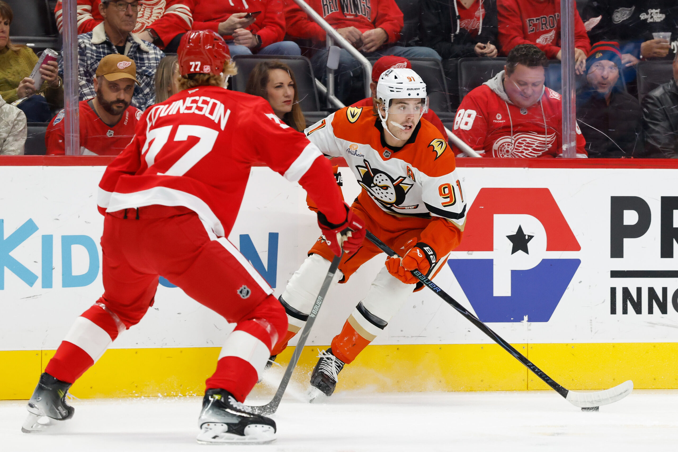 Nov 13, 2025; Detroit, Michigan, USA;  Anaheim Ducks center Leo Carlsson (91) skates with the puck defended by Detroit Red Wings defenseman Simon Edvinsson (77) in the first period at Little Caesars Arena. Mandatory Credit: Rick Osentoski-Imagn Images