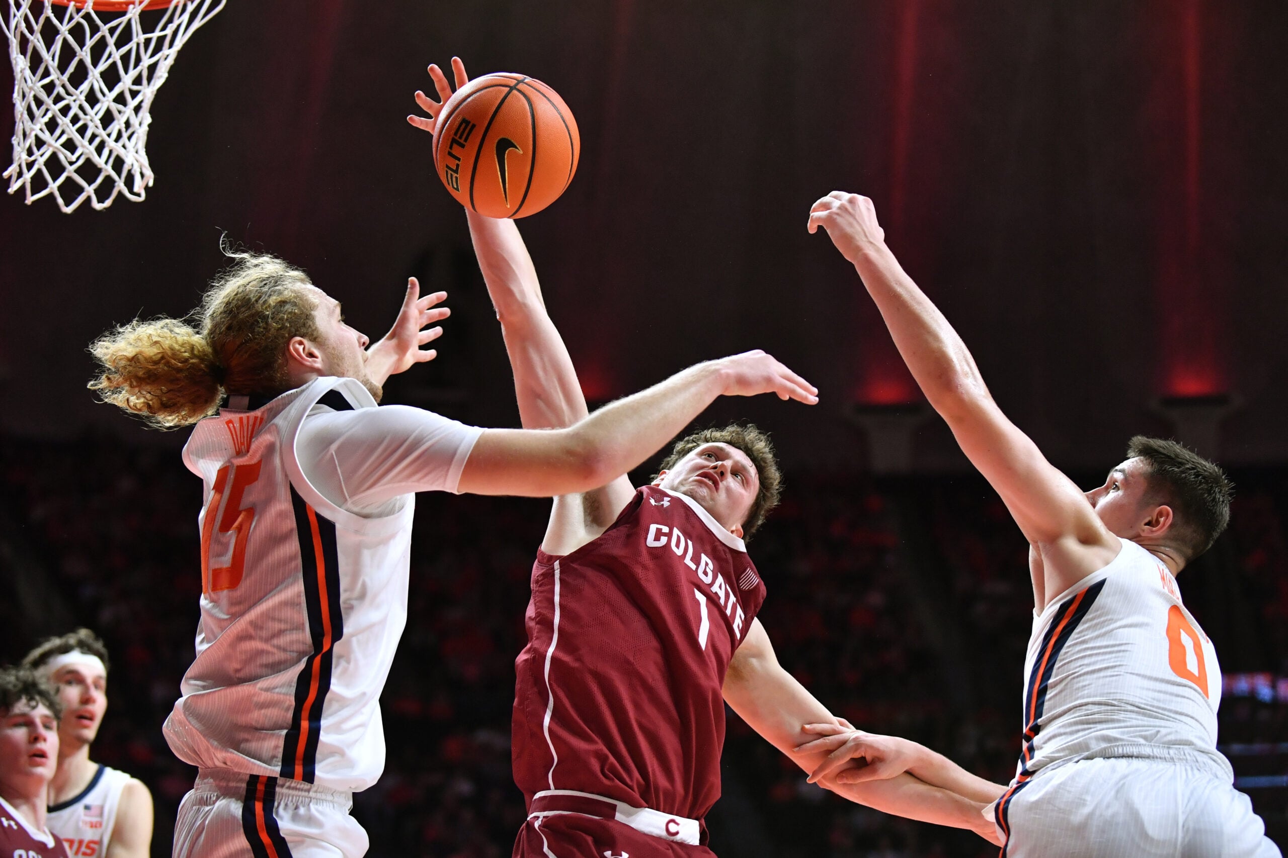 Nov 14, 2025; Champaign, Illinois, USA;  Colgate Raiders guard Brady Cummins (1) tries to pull down a rebound between Illinois Fighting Illini forward Jake Davis (15) and  David Mirkovic (0)during the first half at State Farm Center. Mandatory Credit: Ron Johnson-Imagn Images