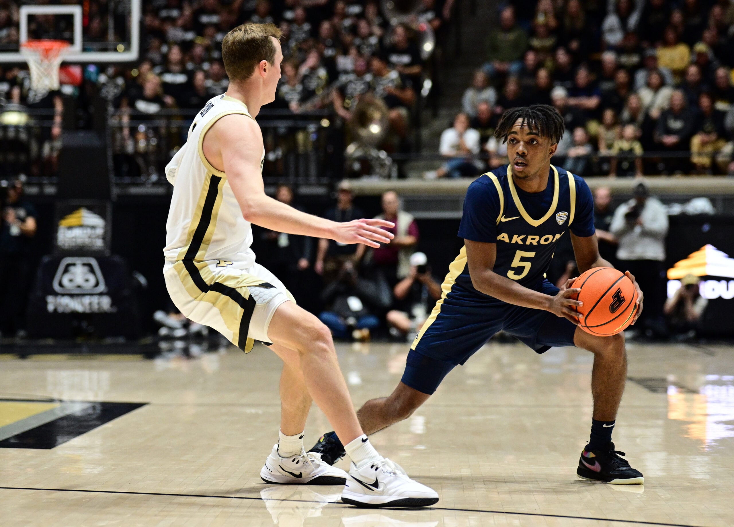 Nov 16, 2025; West Lafayette, Indiana, USA; Akron Zips guard Tavari Johnson (5) looks to get around Purdue Boilermakers guard Fletcher Loyer (2) during the first half at Mackey Arena. Mandatory Credit: Marc Lebryk-Imagn Images