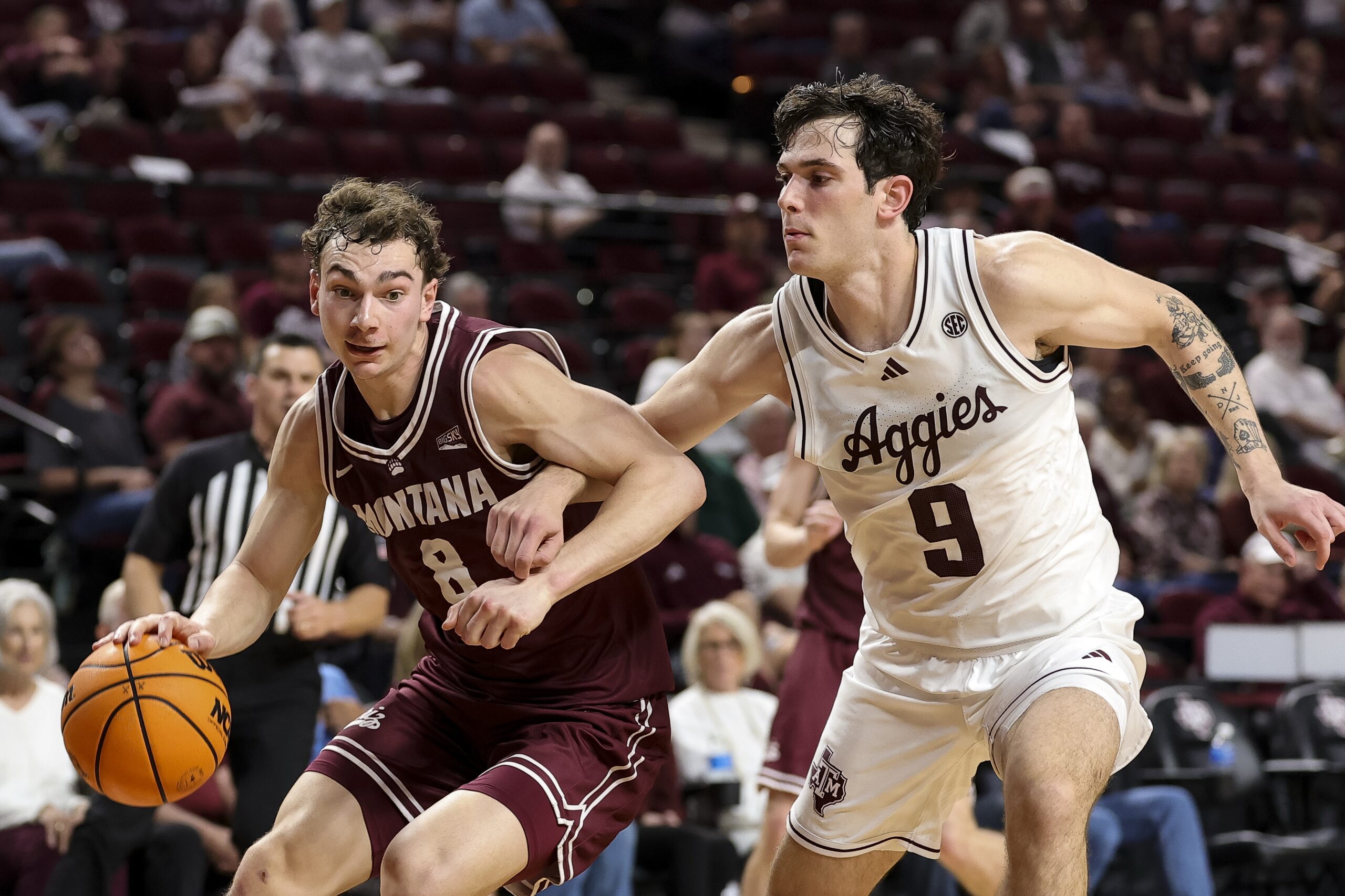 Nov 18, 2025; College Station, Texas, USA; Montana Grizzlies guard Tyler Isaak (8) drives as Texas A&M Aggies guard Ruben Dominguez (9) defends during the second half at Reed Arena. Mandatory Credit: Maria Lysaker-Imagn Images