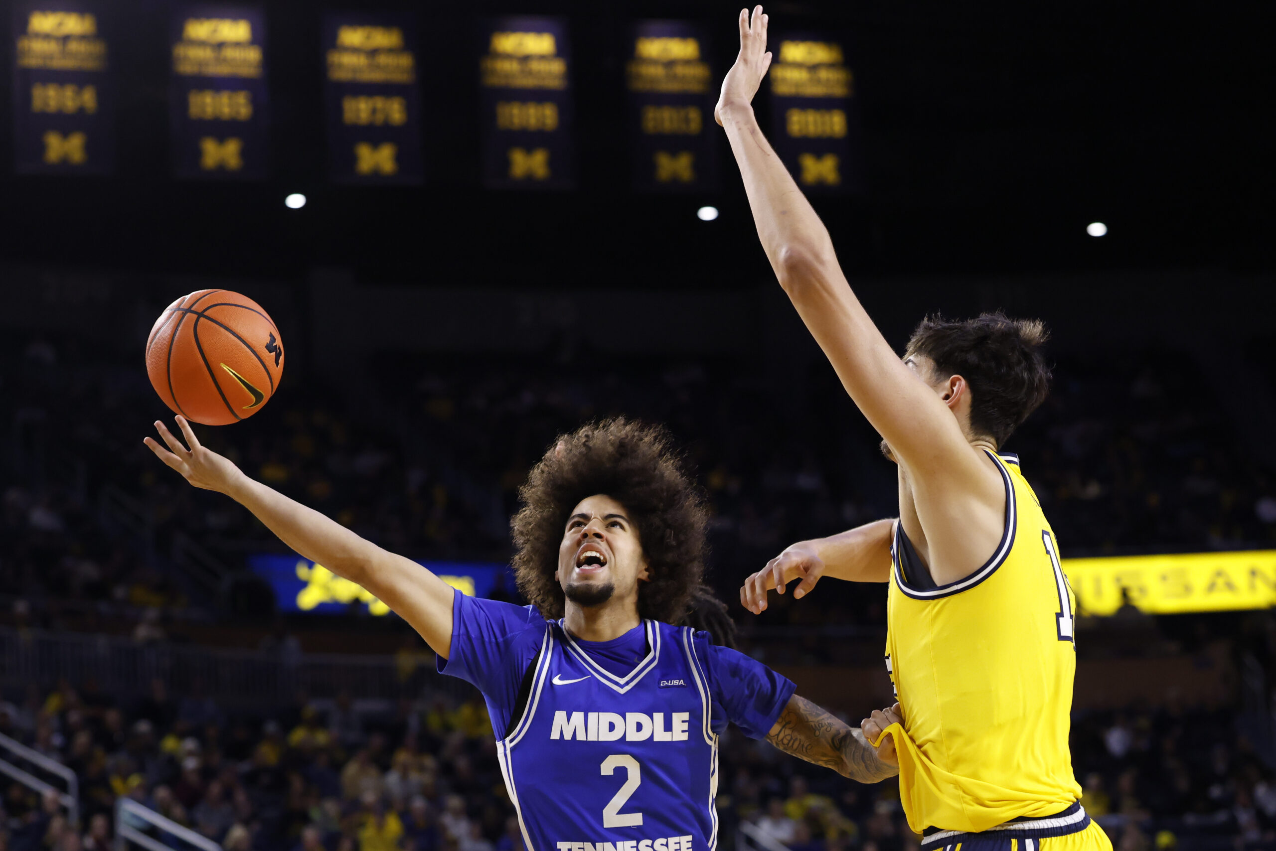 Nov 19, 2025; Ann Arbor, Michigan, USA; Middle Tennessee Blue Raiders guard Jahvin Carter (2) shoots defended by Michigan Wolverines center Aday Mara (15) in the second half at Crisler Center. Mandatory Credit: Rick Osentoski-Imagn Images