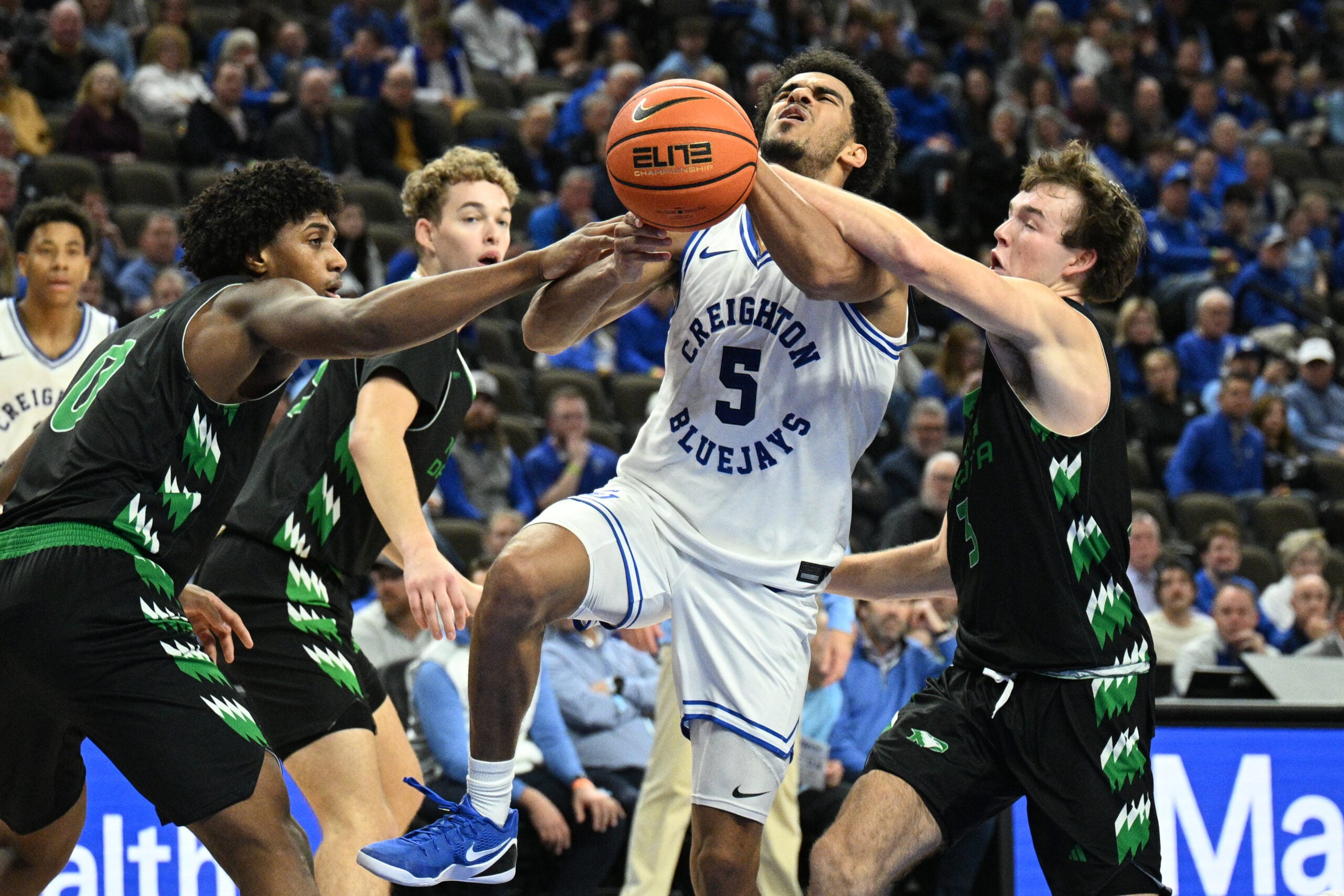 Nov 19, 2025; Omaha, Nebraska, USA;  North Dakota Fighting Hawks guard Greyson Uelmen (3) fouls Creighton Bluejays guard Nik Graves (5) on a shot attempt during the second half at CHI Health Center Omaha. Mandatory Credit: Steven Branscombe-Imagn Images