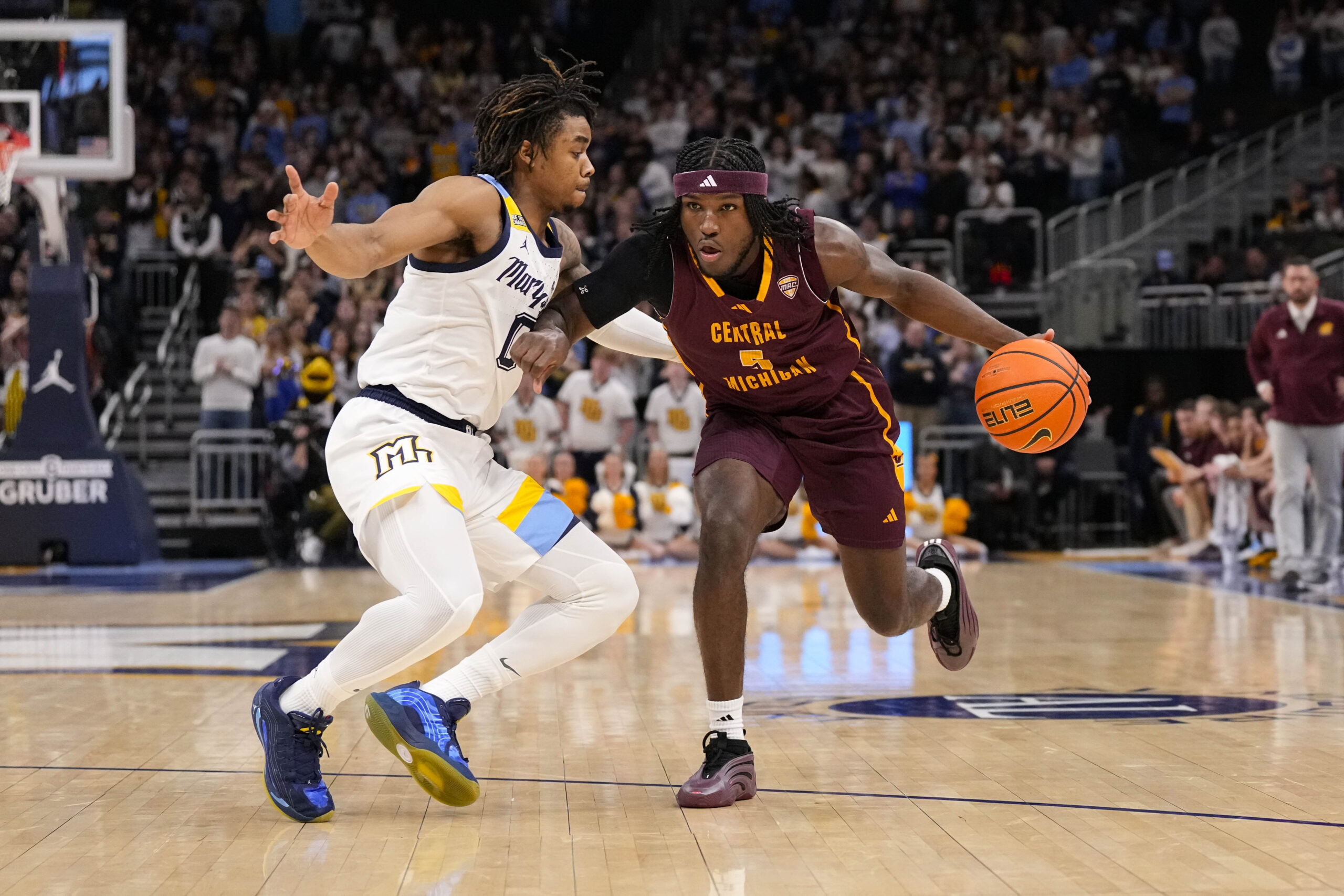 Nov 22, 2025; Milwaukee, Wisconsin, USA;  Central Michigan Chippewas guard Tamario Adley (5) drives for the basket against Marquette Golden Eagles guard Nigel James Jr. (0) during the first half at Fiserv Forum. Mandatory Credit: Jeff Hanisch-Imagn Images