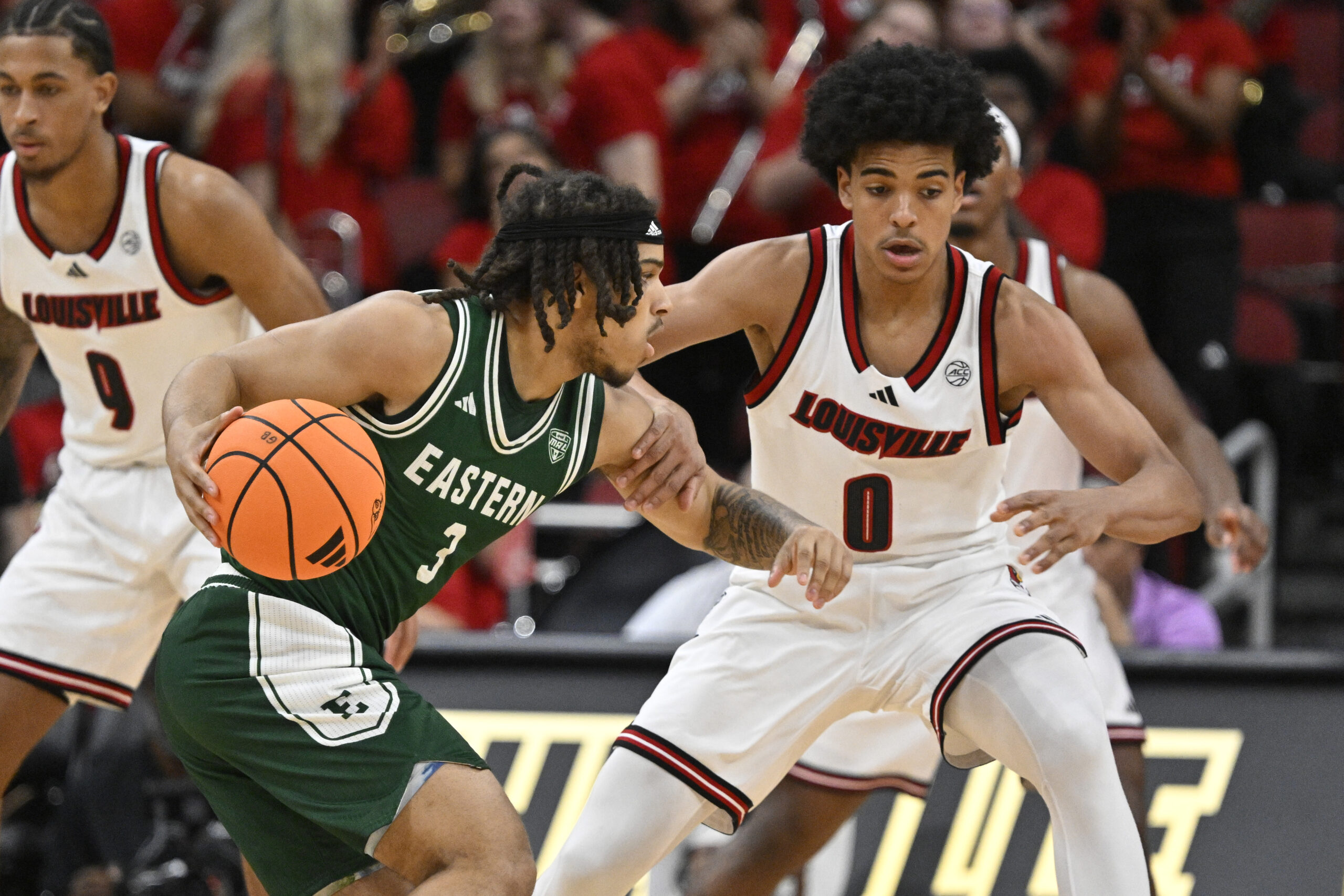 Nov 24, 2025; Louisville, Kentucky, USA; Eastern Michigan Eagles guard Mehki Ellison (3) dribbles against Louisville Cardinals guard Mikel Brown Jr. (0) during the second half at KFC Yum! Center. Louisville defeated Eastern Michigan 87-46. Mandatory Credit: Jamie Rhodes-Imagn Images