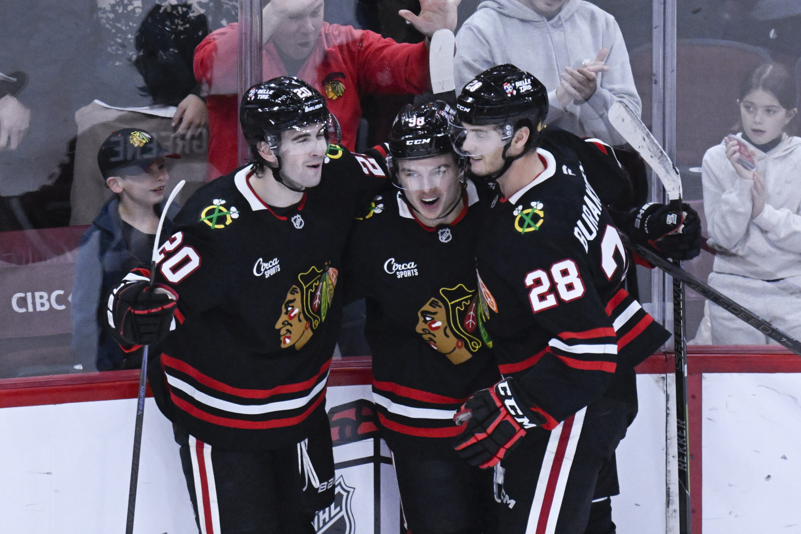 Nov 30, 2025; Chicago, Illinois, USA;  Chicago Blackhawks center Connor Bedard (98) celebrates with  center Ryan Greene (20) and  left wing Andre Burakovsky (28)  after he scores a goal against the Anaheim Ducks during the third period at United Center. Mandatory Credit: Matt Marton-Imagn Images