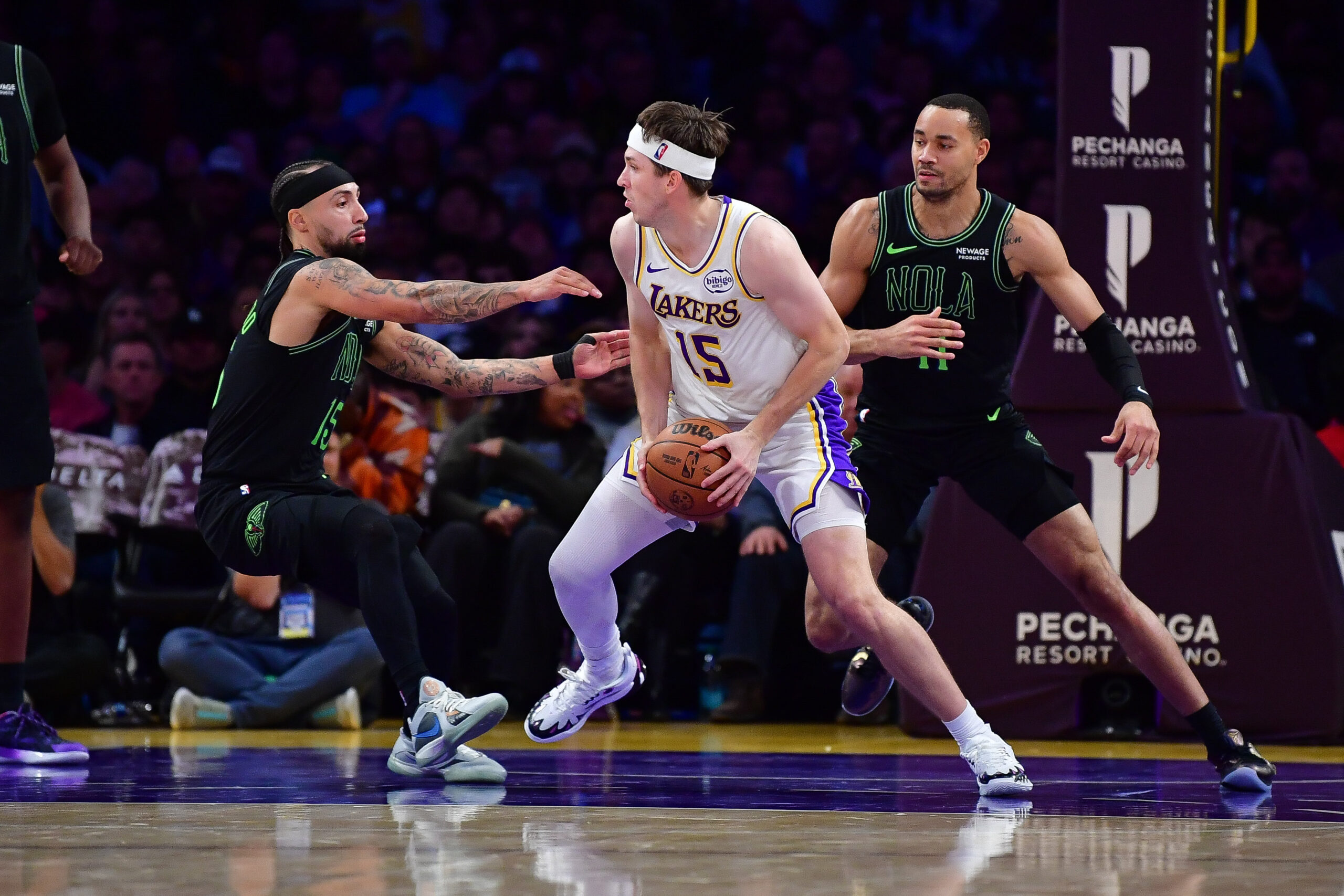 Nov 30, 2025; Los Angeles, California, USA; Los Angeles Lakers guard Austin Reaves (15) moves to the basket against New Orleans Pelicans guard Jose Alvarado (15) and guard Bryce McGowens (11) during the second half at Crypto.com Arena. Mandatory Credit: Gary A. Vasquez-Imagn Images