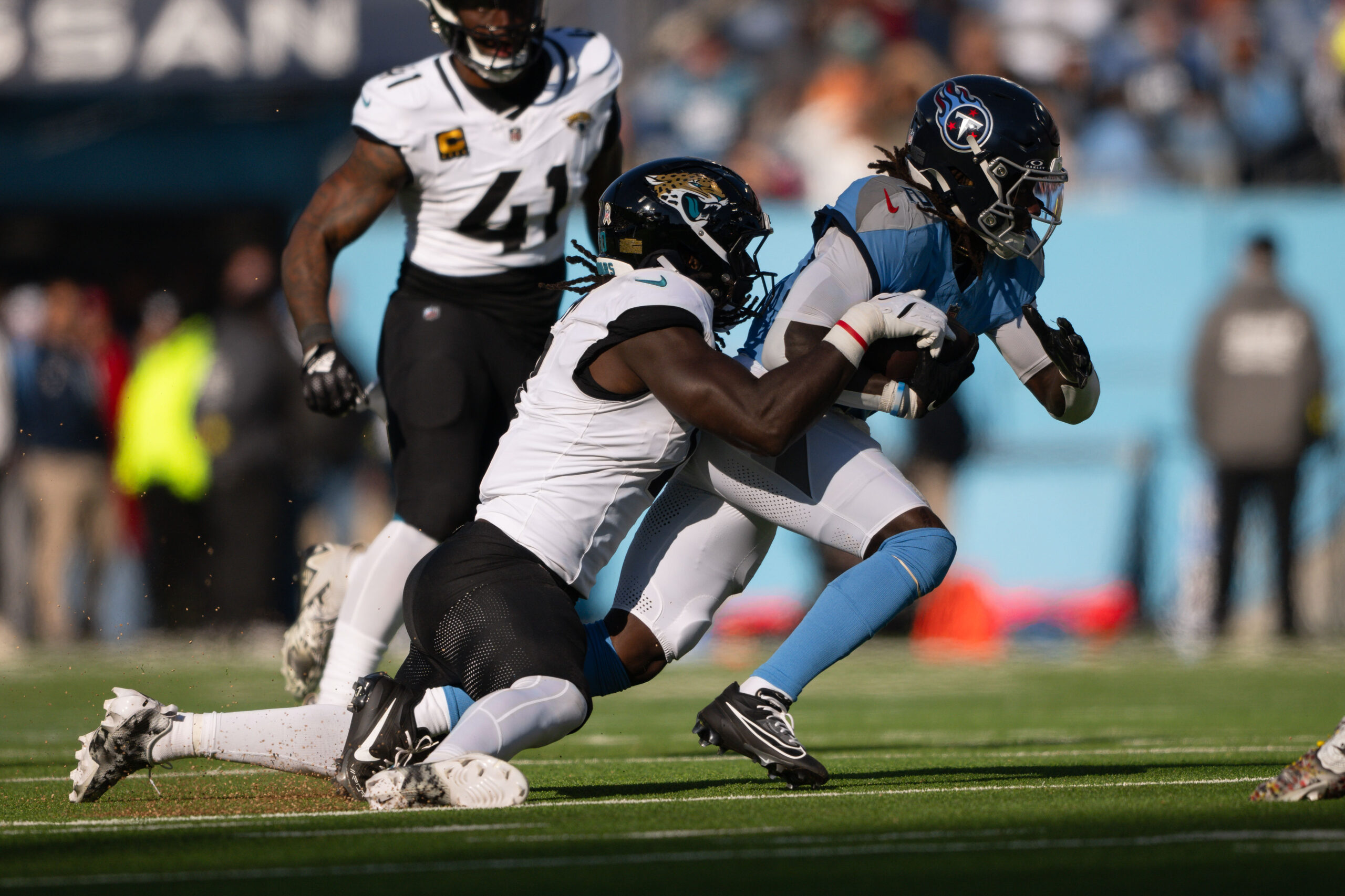 Nov 30, 2025; Nashville, Tennessee, USA;  Jacksonville Jaguars cornerback Montaric Brown (30) tackles Tennessee Titans running back Tyjae Spears (2) during the first half at Nissan Stadium. Mandatory Credit: Steve Roberts-Imagn Images