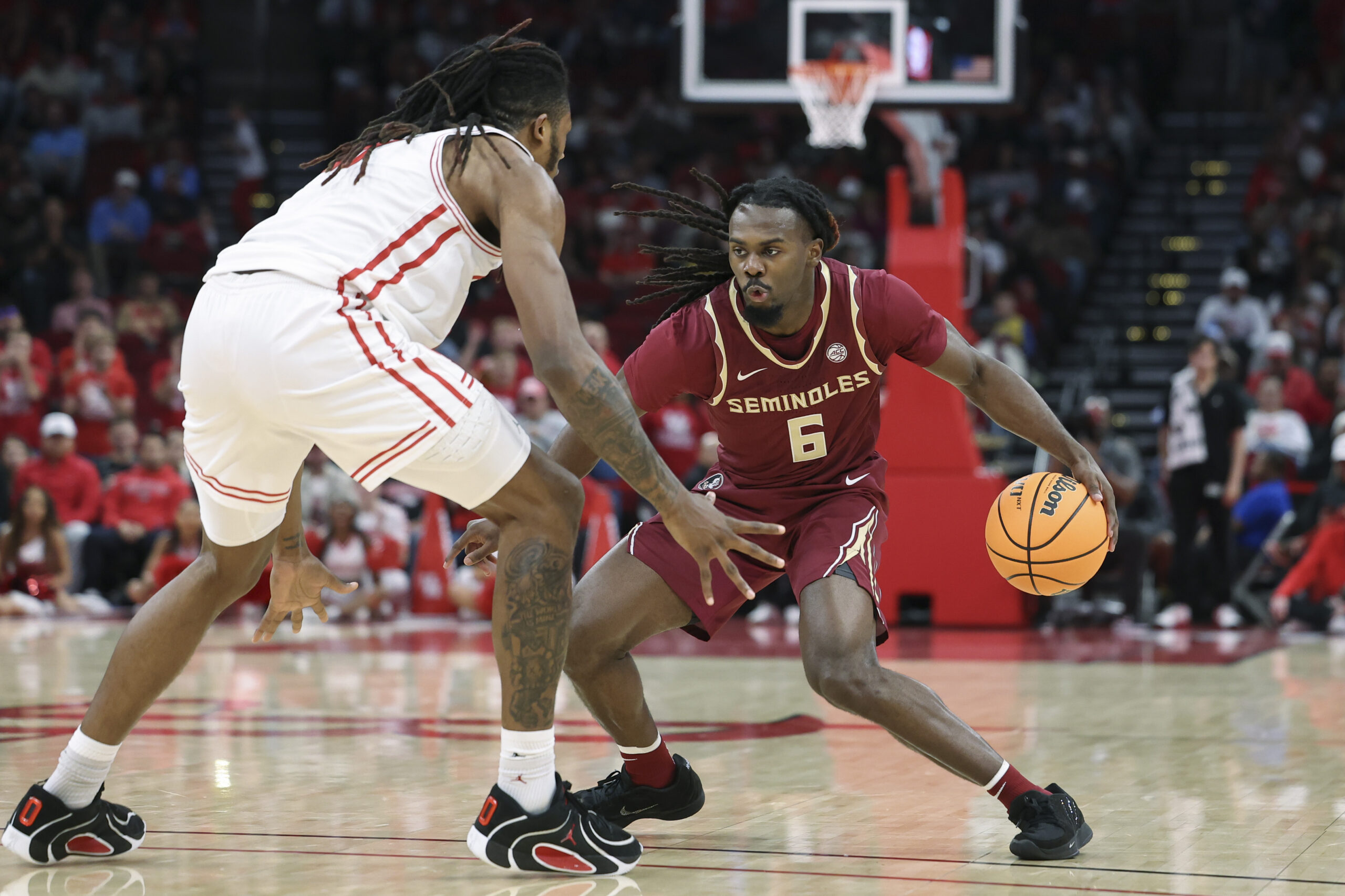 Dec 6, 2025; Houston, TX, USA; Florida State Seminoles guard Robert McCray V (6) dribbles the ball as Houston Cougars forward Joseph Tugler (11) defends during the second half at Toyota Center. Mandatory Credit: Troy Taormina-Imagn Images