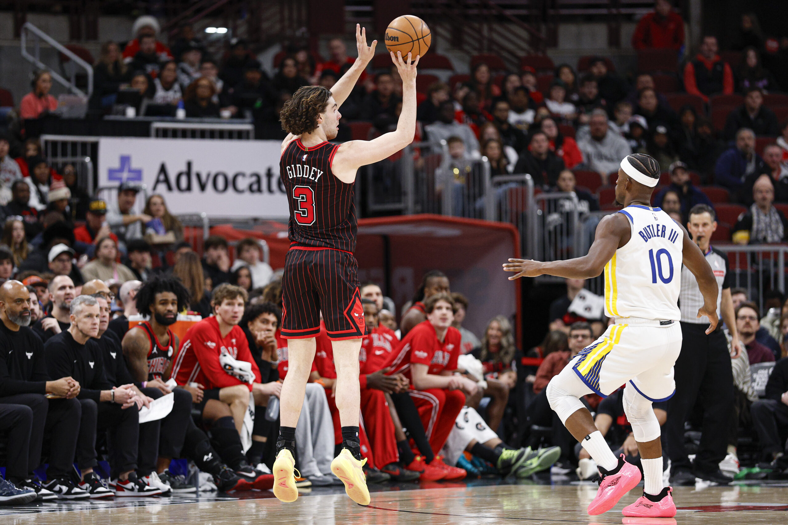 Dec 7, 2025; Chicago, Illinois, USA; Chicago Bulls guard Josh Giddey (3) shoots against Golden State Warriors forward Jimmy Butler III (10) during the second half at United Center. Mandatory Credit: Kamil Krzaczynski-Imagn Images