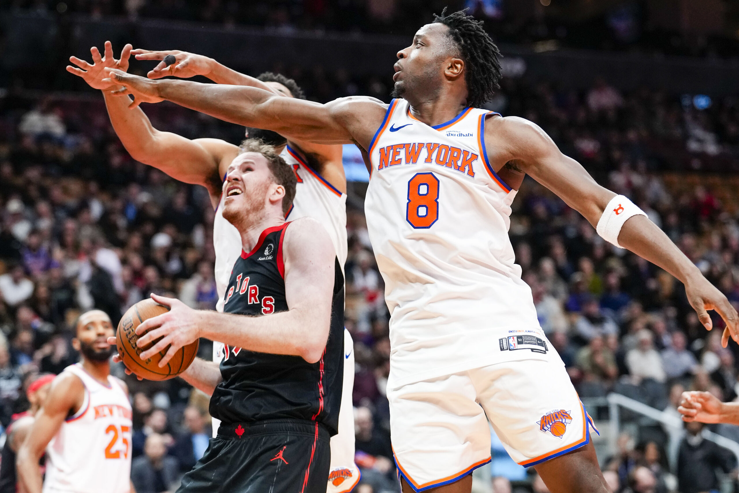 Dec 9, 2025; Toronto, Ontario, CAN;  Toronto Raptors center Jakob Poeltl (19) drives to the basket against New York Knicks forward Og Anunoby (8) during the second half at the 2025-26 NBA Emirates Cup at Scotiabank Arena. Mandatory Credit: Kevin Sousa-Imagn Images