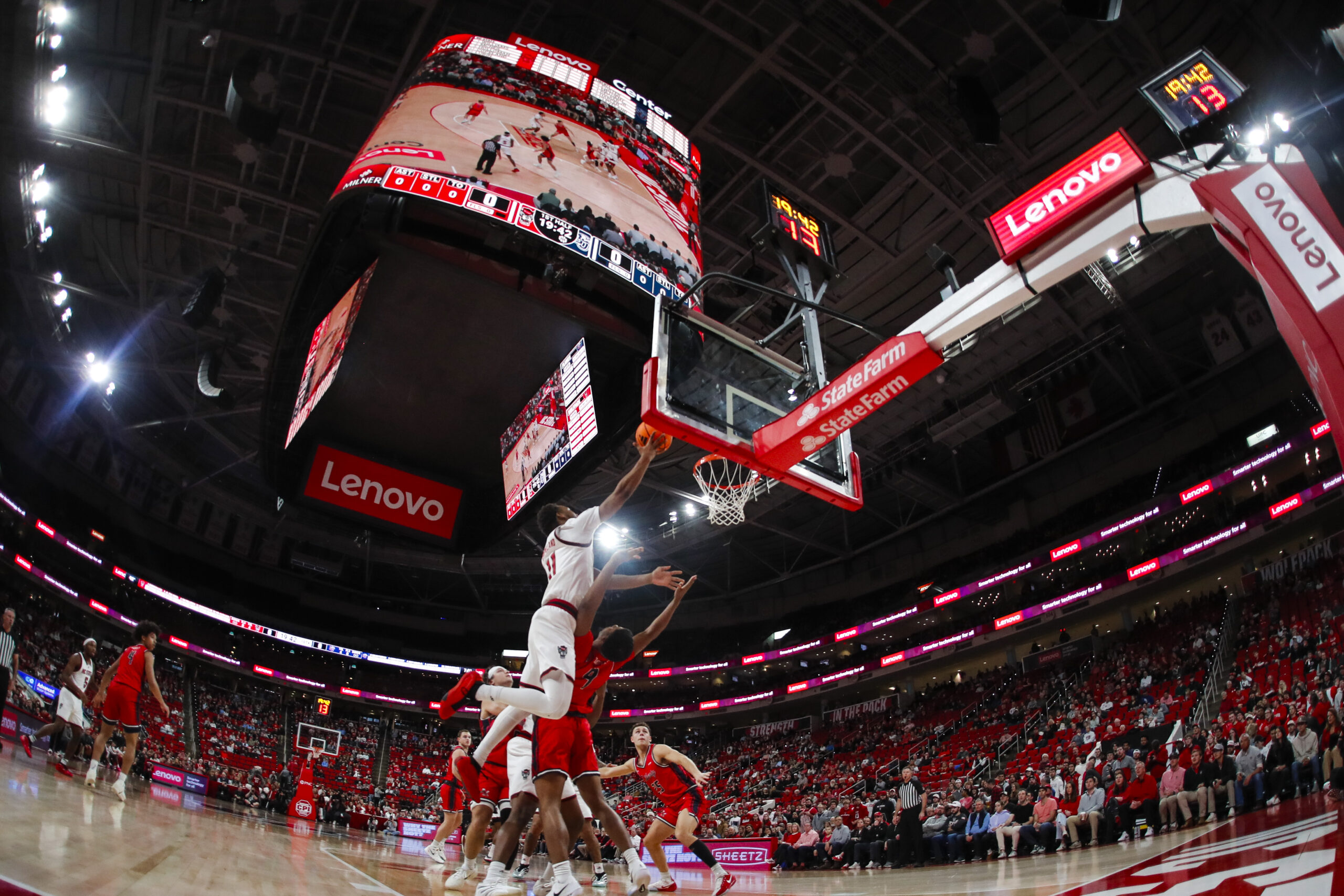 Dec 6, 2025; Raleigh, North Carolina, USA; NC State Wolfpack guard Quadir Copeland (11) dunks the ball past Liberty Flames guard JJ Harper (9) during the first half of the game at Lenovo Center. Mandatory Credit: Jaylynn Nash-Imagn Images