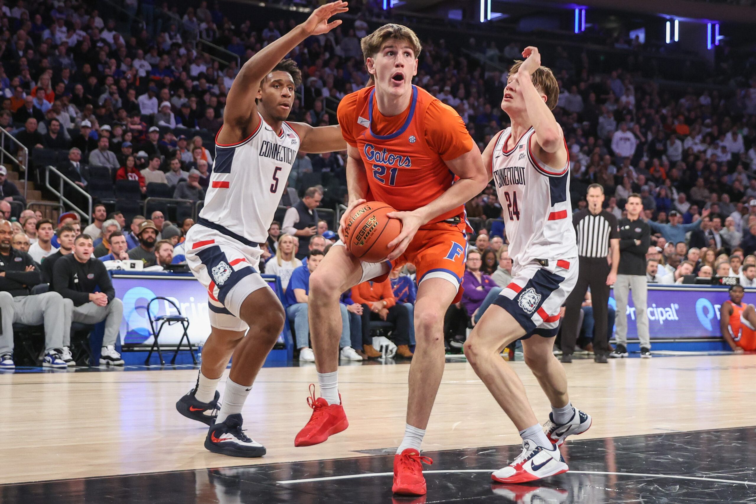 Dec 9, 2025; New York, New York, USA;  Florida Gators forward Alex Condon (21) and UConn Huskies forward Tarris Reed Jr. (5) and guard Braylon Mullins (24) at Madison Square Garden. Mandatory Credit: Wendell Cruz-Imagn Images