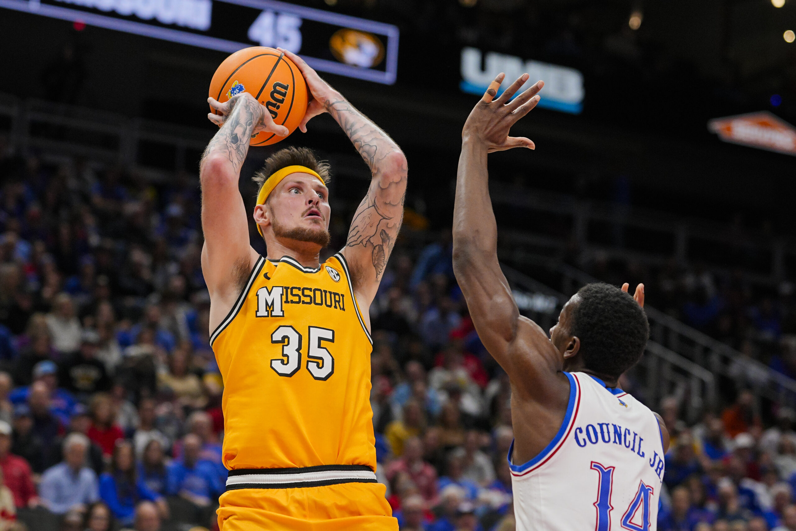 Dec 7, 2025; Kansas City, Missouri, USA; Missouri Tigers guard Jacob Crews (35) shoots against Kansas Jayhawks guard Melvin Council Jr. (14) during the second half at T-Mobile Center. Mandatory Credit: Jay Biggerstaff-Imagn Images