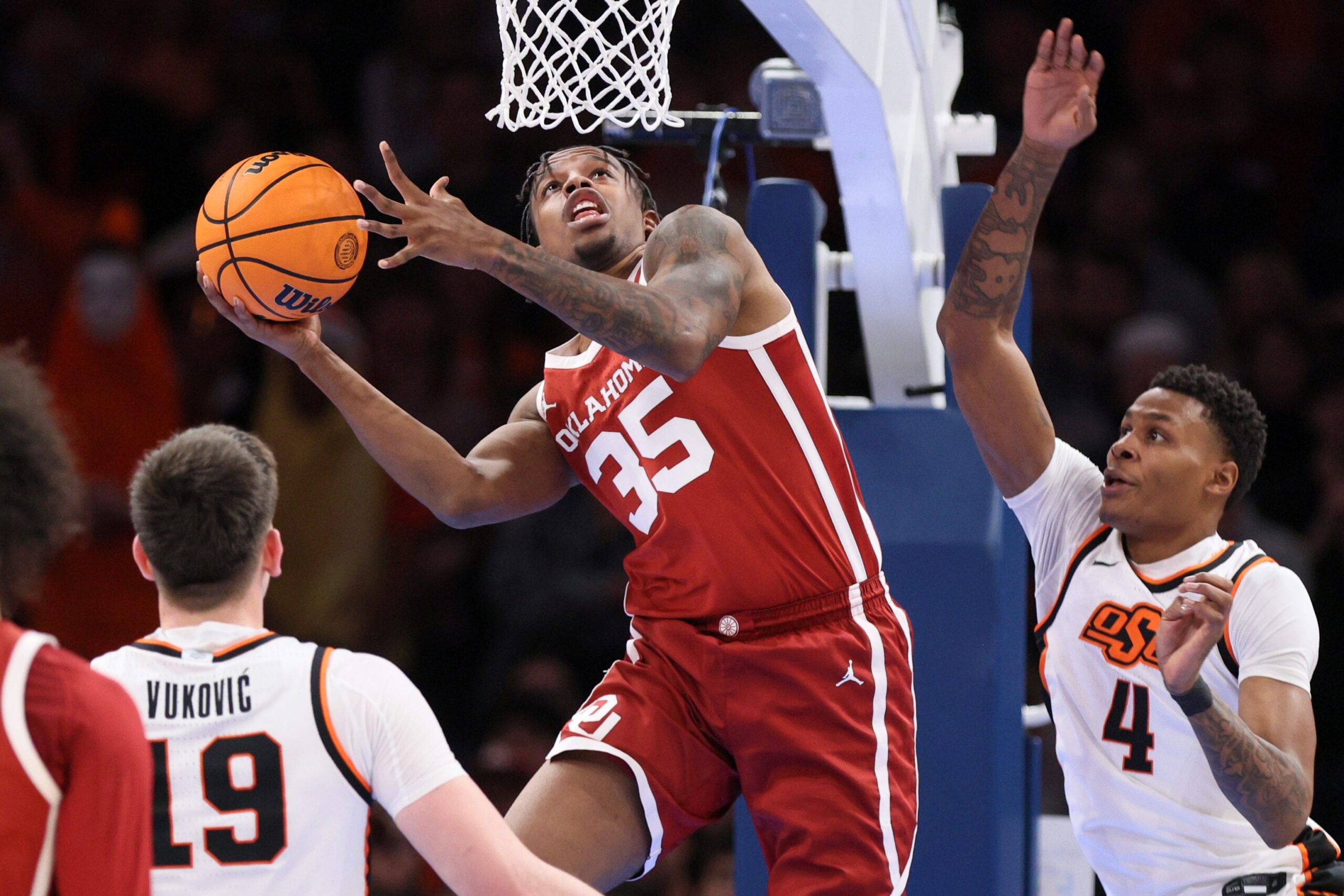 Oklahoma forward Derrion Reid (35) looks to shoot between Oklahoma State forwards Andrija Vukovic (19) and Christian Coleman (4) during the first half of a Bedlam men's college basketball game between the OSU Cowboys and OU Sooners at Paycom Center in Oklahoma City, Saturday, Dec. 13, 2025.