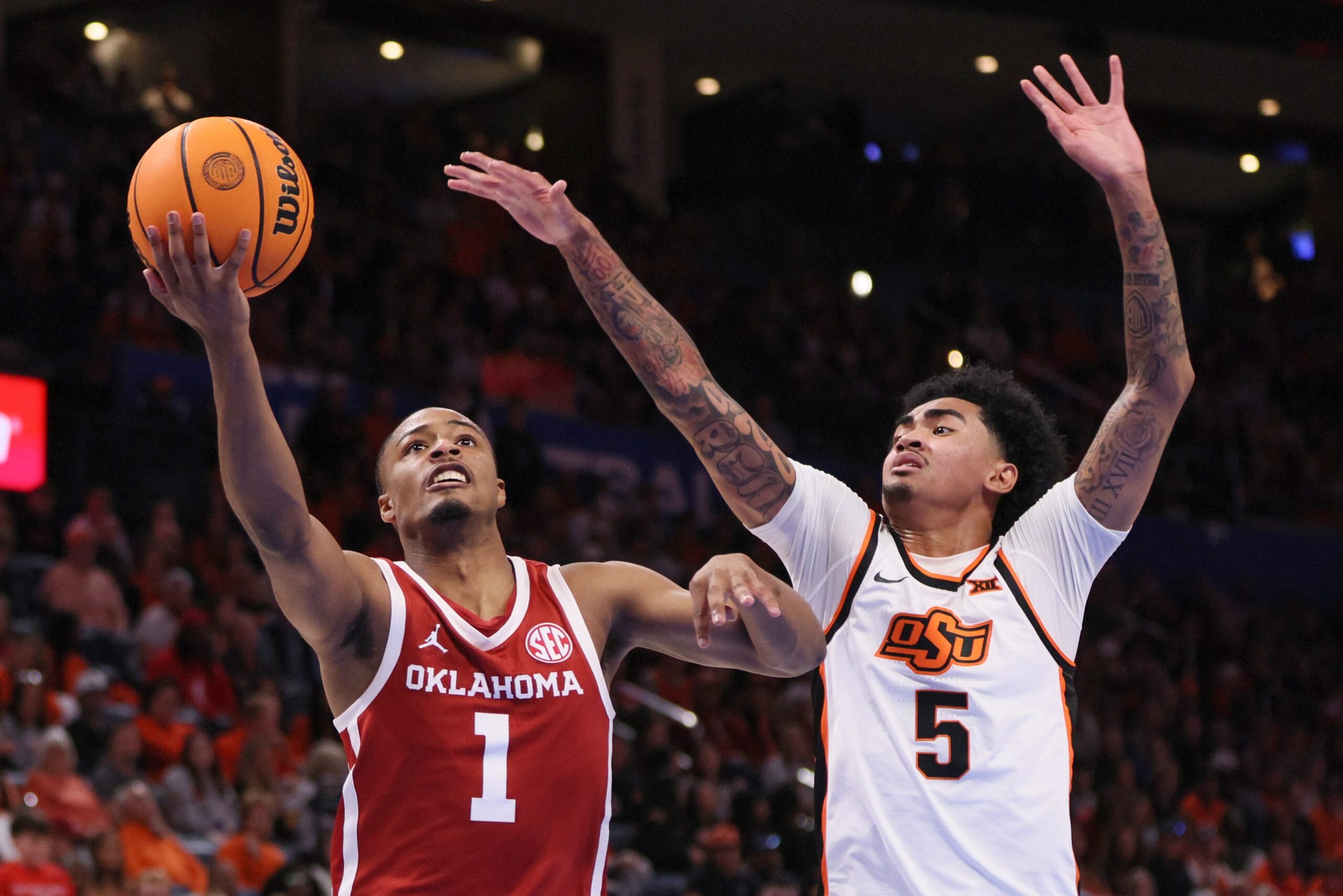 Oklahoma guard Xzayvier Brown (1) looks to shoot next to Oklahoma State guard Vyctorius Miller (5) during the second half of a Bedlam men's college basketball game between the OSU Cowboys and OU Sooners at Paycom Center in Oklahoma City, Saturday, Dec. 13, 2025.