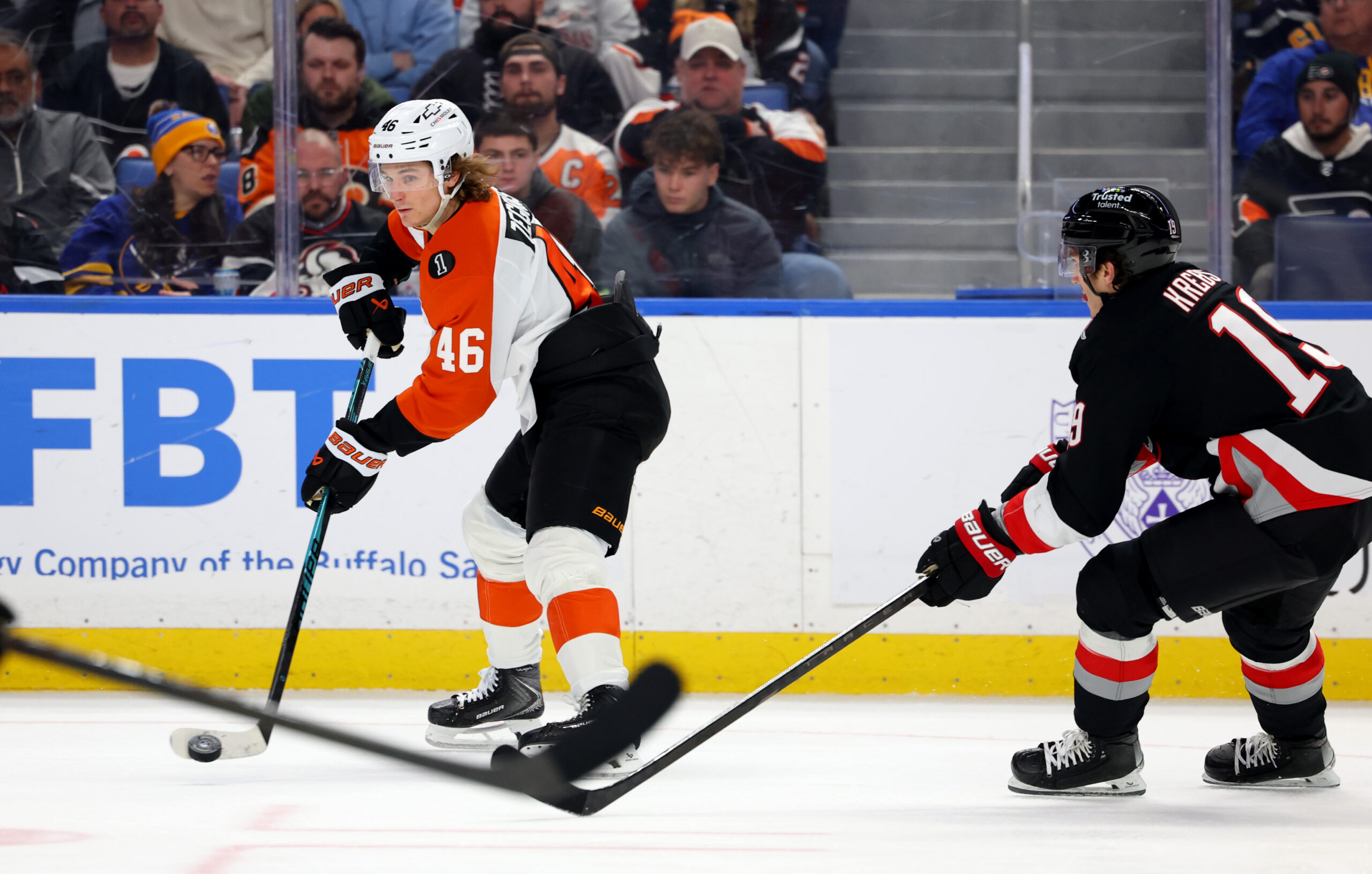 Dec 18, 2025; Buffalo, New York, USA;  Philadelphia Flyers center Trevor Zegras (46) makes a pass as Buffalo Sabres center Peyton Krebs (19) tries to block it during the third period at KeyBank Center. Mandatory Credit: Timothy T. Ludwig-Imagn Images