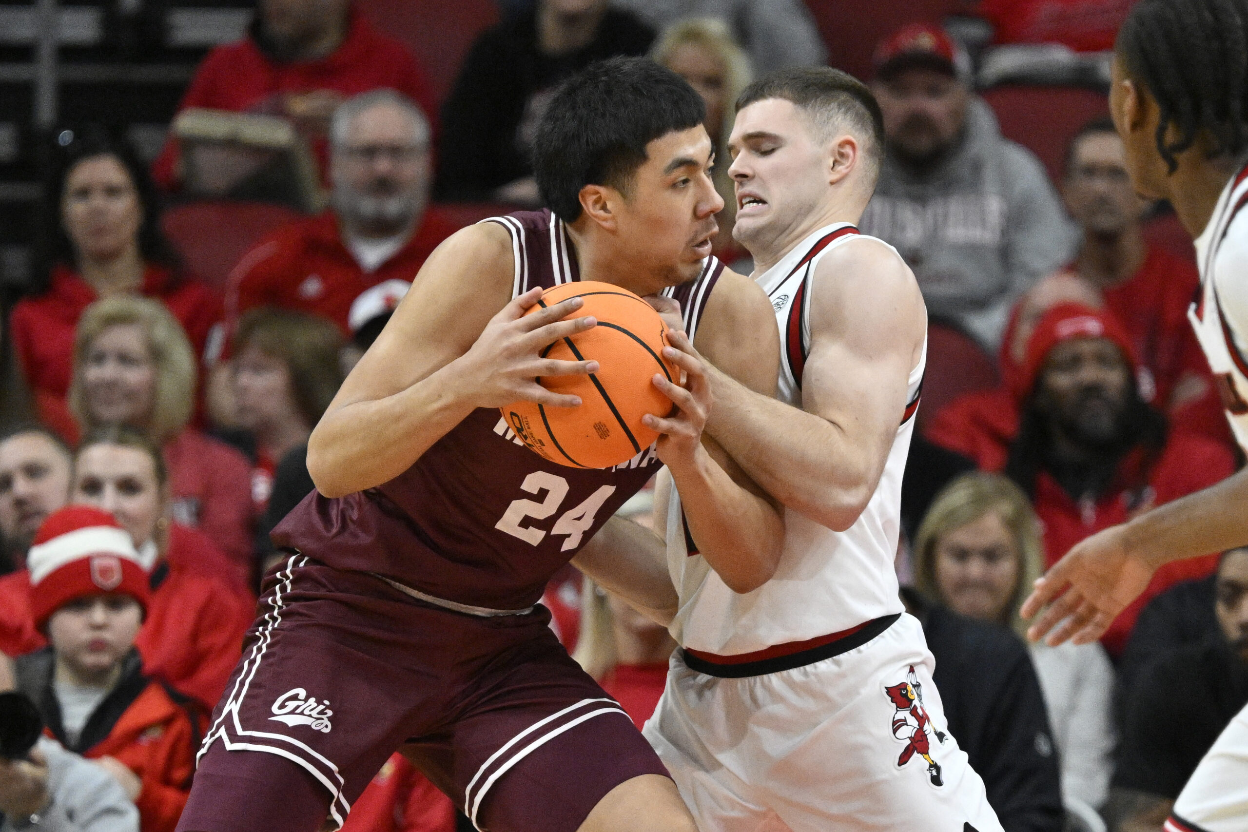 Dec 20, 2025; Louisville, Kentucky, USA; Montana Grizzlies forward Kenyon Aguino (24) posts up against Louisville Cardinals guard Isaac McKneely (10) during the first half at KFC Yum! Center. Mandatory Credit: Jamie Rhodes-Imagn Images