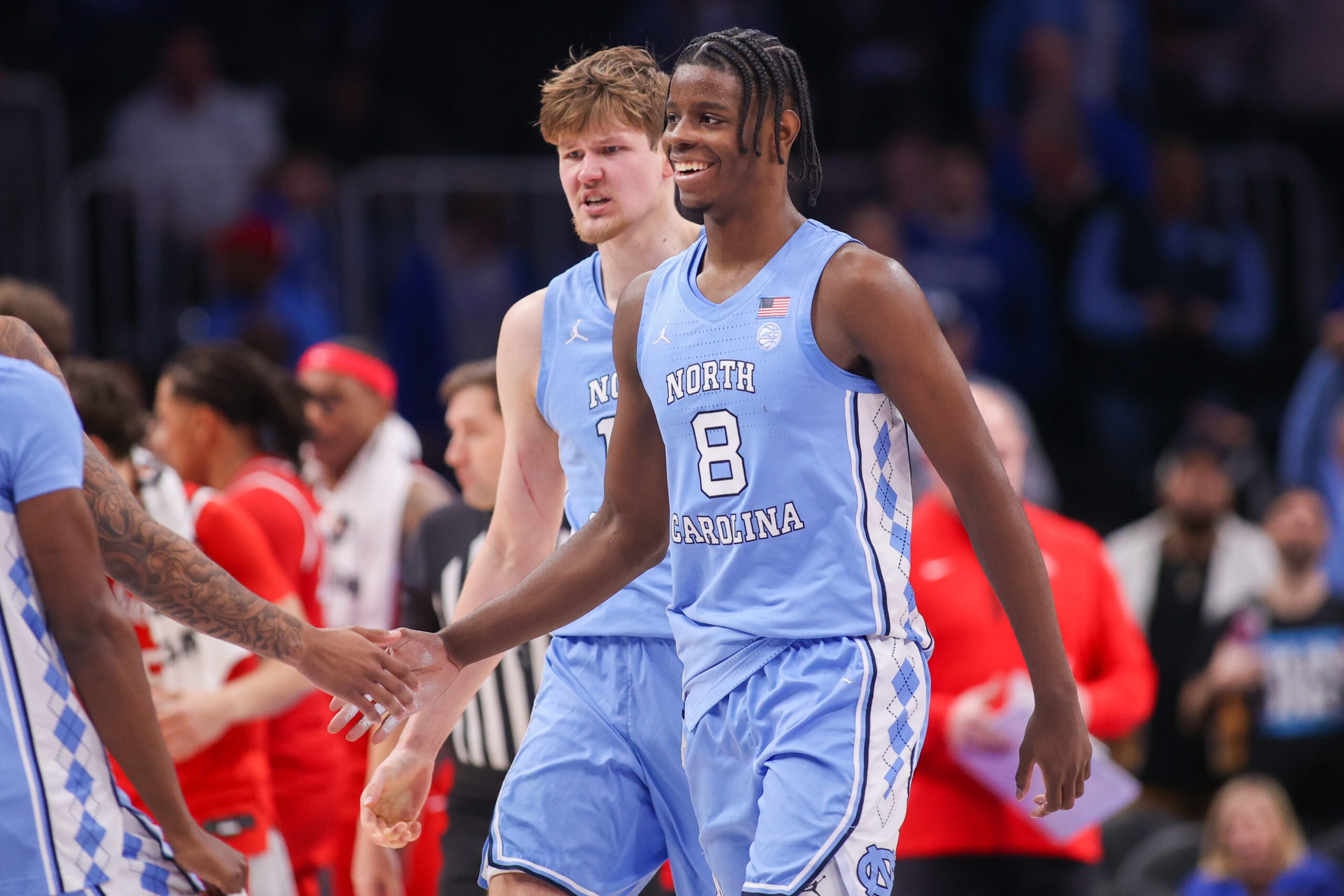 Dec 20, 2025; Atlanta, Georgia, USA; North Carolina Tar Heels forward Caleb Wilson (8) and center Henri Veesaar (13) celebrate during a timeout against the Ohio State Buckeyes in the second half at State Farm Arena. Mandatory Credit: Brett Davis-Imagn Images