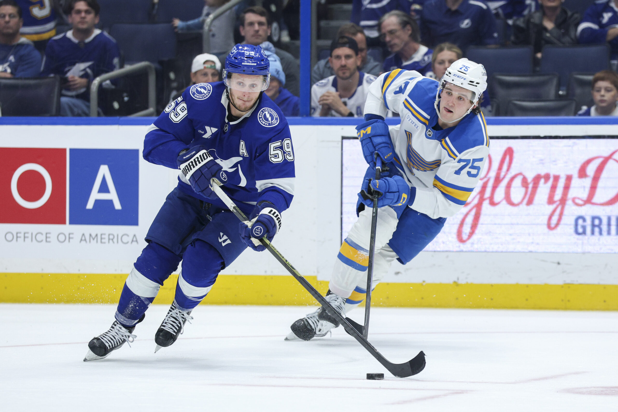 Dec 22, 2025; Tampa, Florida, USA; Tampa Bay Lightning center Jake Guentzel (59) controls the puck from St. Louis Blues defenseman Tyler Tucker (75) in the third period at Benchmark International Arena. Mandatory Credit: Nathan Ray Seebeck-Imagn Images