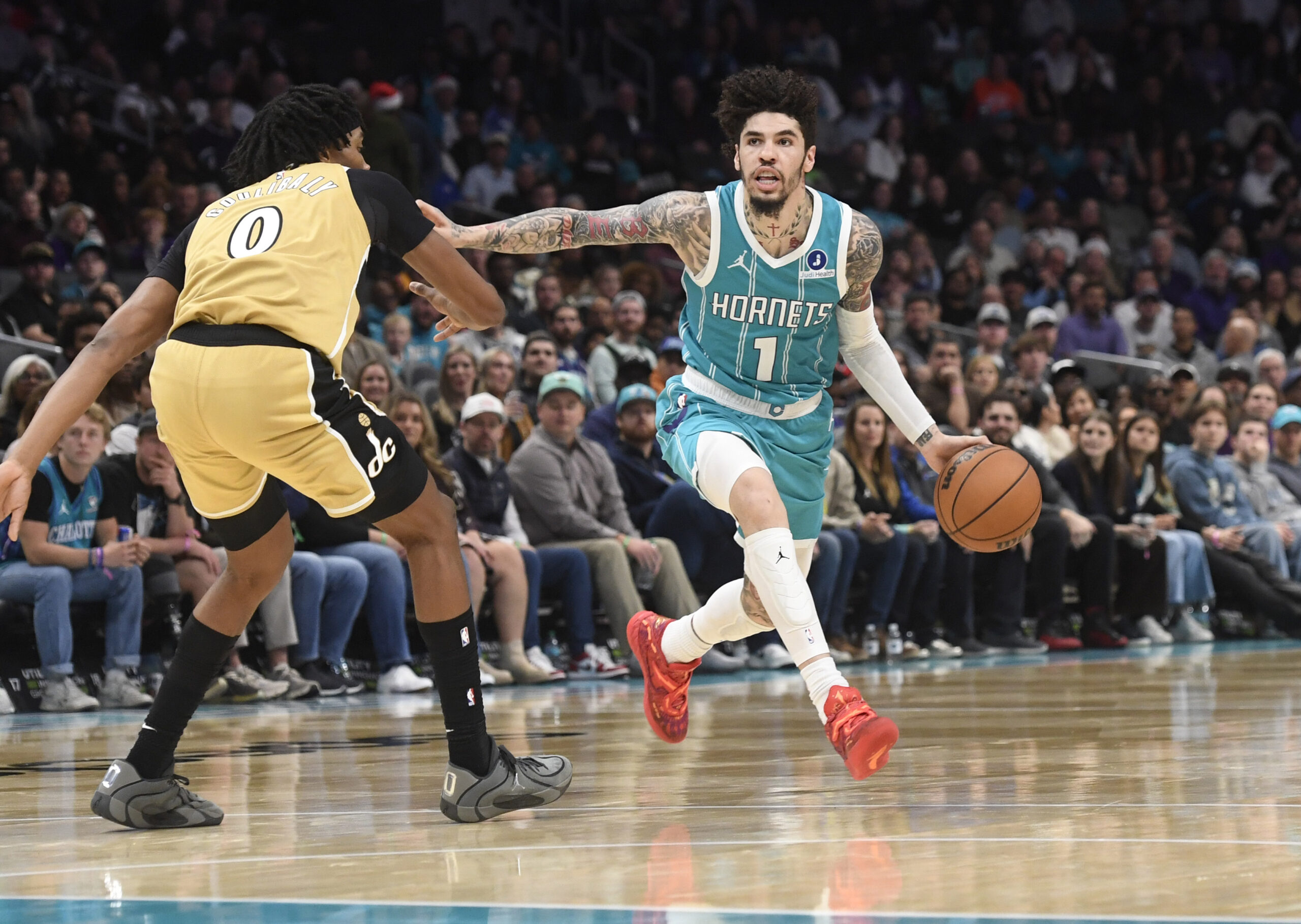Dec 23, 2025; Charlotte, North Carolina, USA;  Charlotte Hornets guard LaMelo Ball (1) drives past Washington Wizards forward Bilal Coulibaly (0) during the second half at the Spectrum Center. Mandatory Credit: Sam Sharpe-Imagn Images