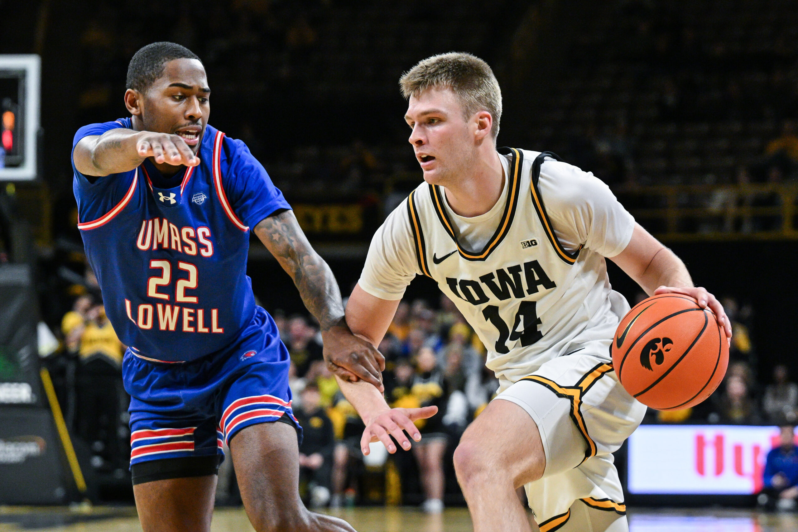 Dec 29, 2025; Iowa City, Iowa, USA; Iowa Hawkeyes guard Bennett Stirtz (14) controls the ball as UMass Lowell River Hawks guard Khalil Farmer (22) defends during the second half at Carver-Hawkeye Arena. Mandatory Credit: Jeffrey Becker-Imagn Images