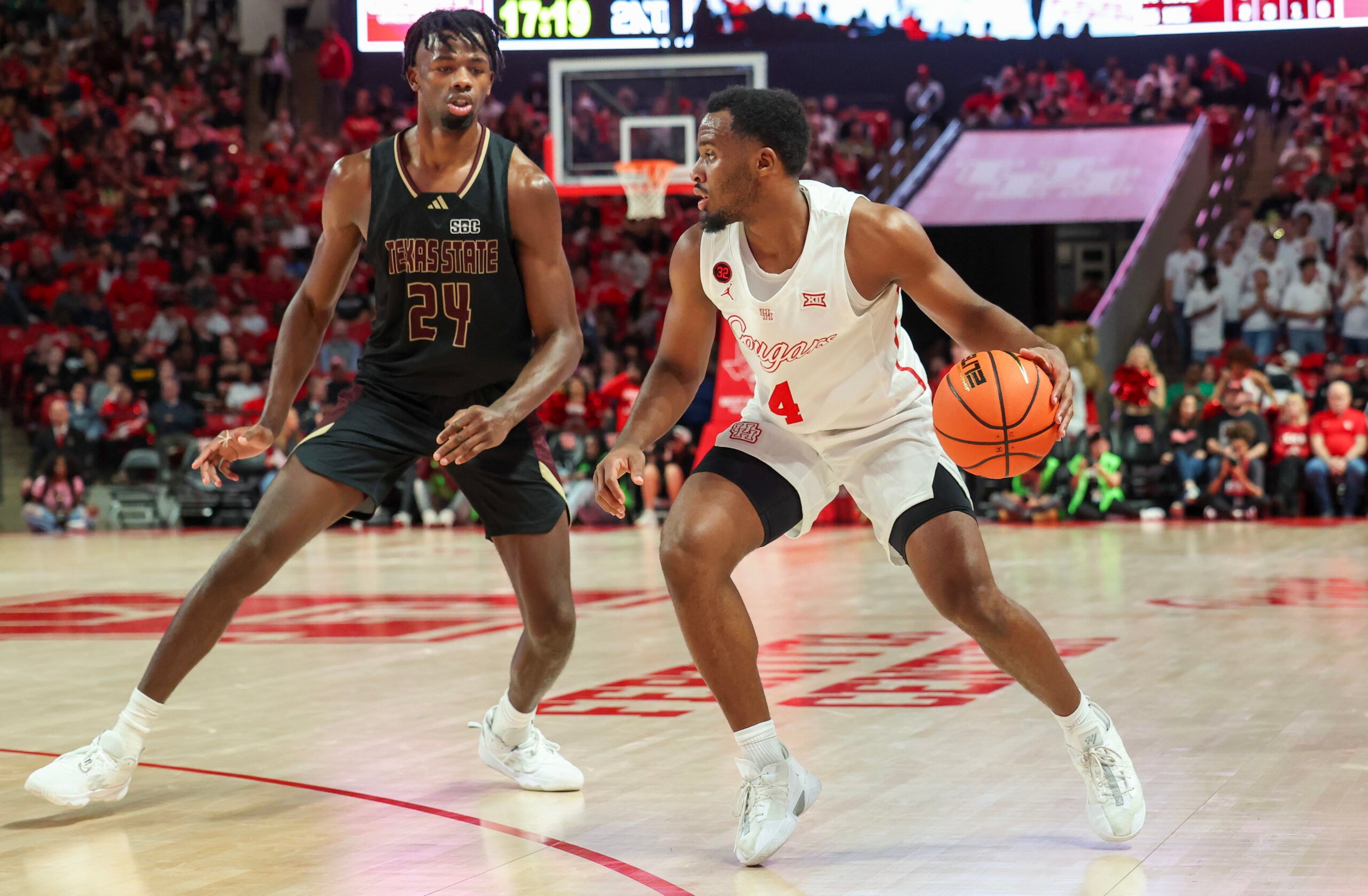 Dec 21, 2023; Houston, Texas, USA;  Houston Cougars guard L.J. Cryer (4) dribbles against Texas State Bobcats forward Brandon Love (24) in the second half at Fertitta Center. Mandatory Credit: Thomas Shea-Imagn Images