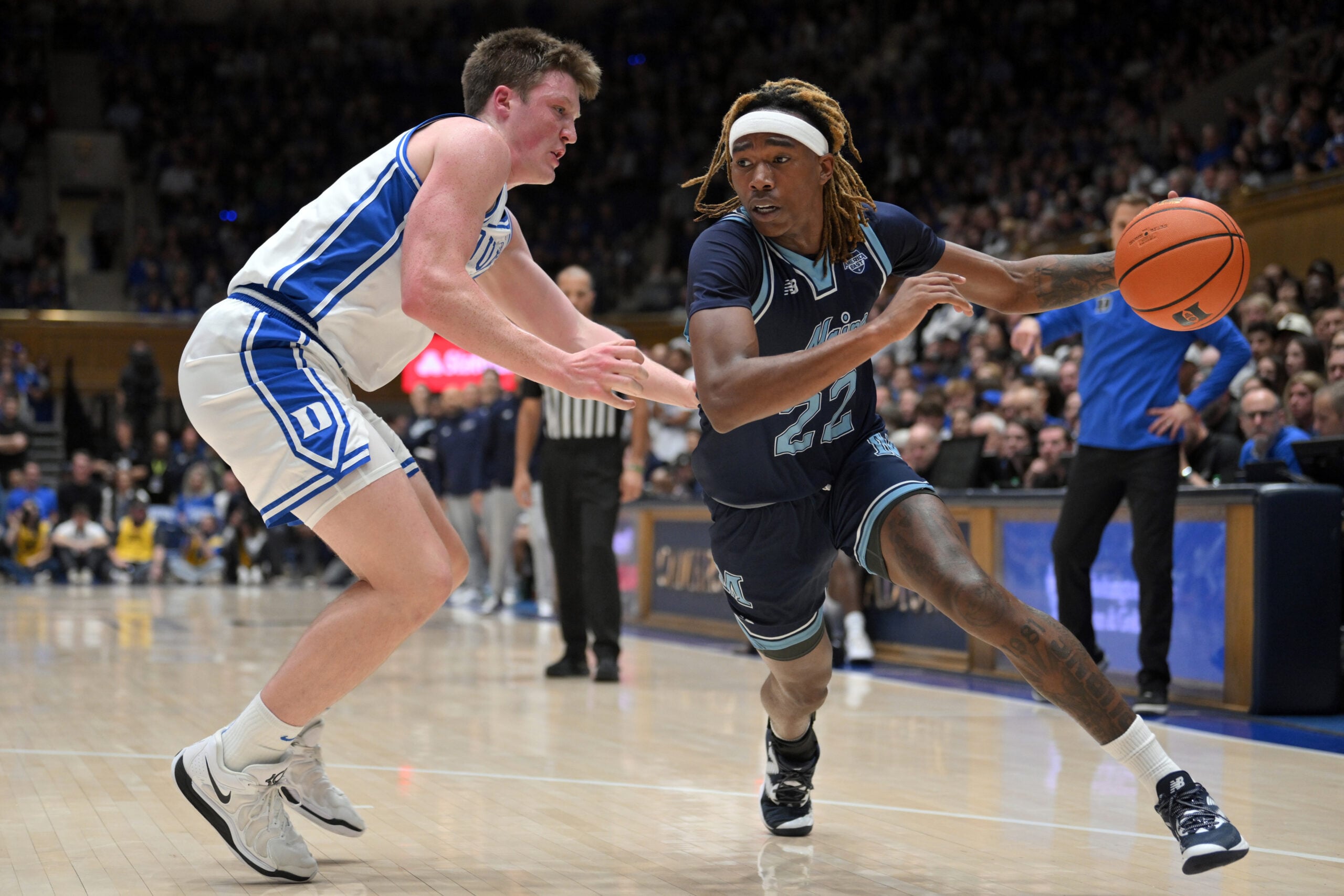 Nov 4, 2024; Durham, North Carolina, USA;  Maine Black Bears guard Quion Burns (22) drives the ball while under pressure from Duke Blue Devils guard Kon Knueppel (7) in the first half at Cameron Indoor Stadium. Mandatory Credit: Zachary Taft-Imagn Images
