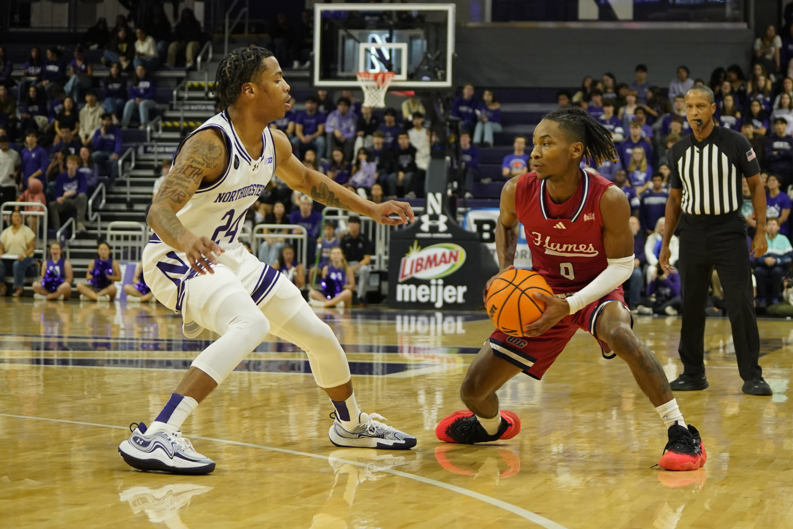 Nov 12, 2024; Evanston, Illinois, USA; Northwestern Wildcats guard K.J. Windham (24) defends Illinois-Chicago Flames guard Ahmad Henderson II (0) during the first half at Welsh-Ryan Arena. Mandatory Credit: David Banks-Imagn Images