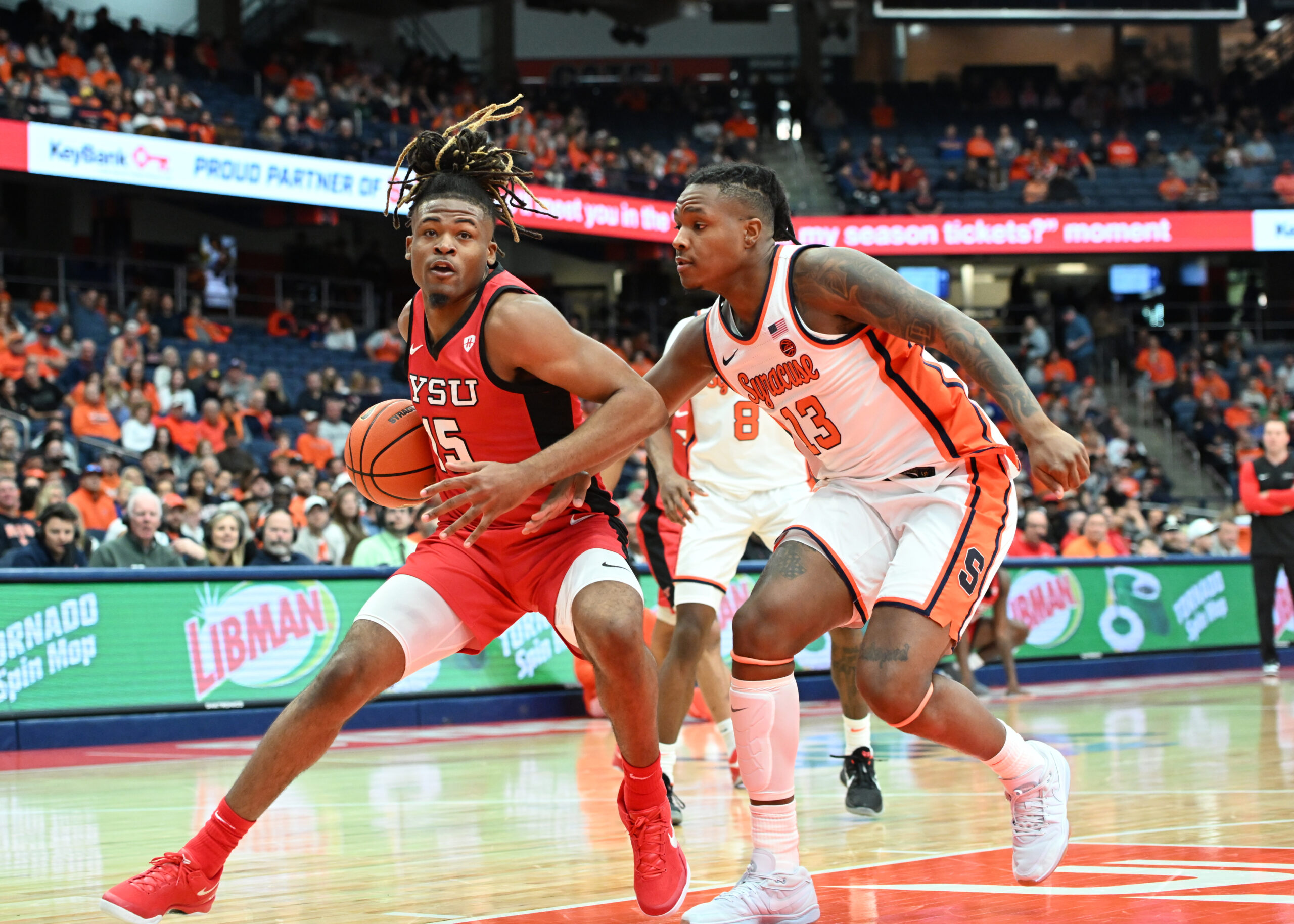 Nov 16, 2024; Syracuse, New York, USA; Youngstown State Penguins forward Cris Carroll (15) looks to the basket with Syracuse Orange forward Jyare Davis (13) defending in the first half at the JMA Wireless Dome. Mandatory Credit: Mark Konezny-Imagn Images