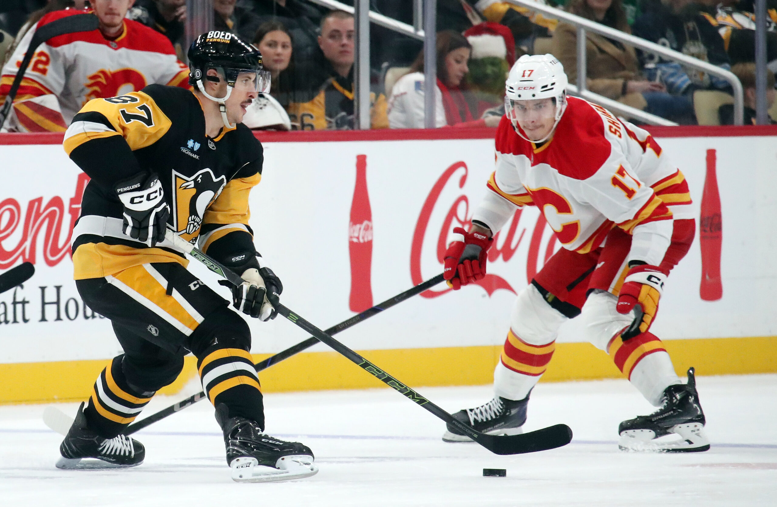 Nov 30, 2024; Pittsburgh, Pennsylvania, USA;  Pittsburgh Penguins center Sidney Crosby (87) moves the puck against Calgary Flames center Yegor Sharangovich (17) during the third period at PPG Paints Arena. Mandatory Credit: Charles LeClaire-Imagn Images