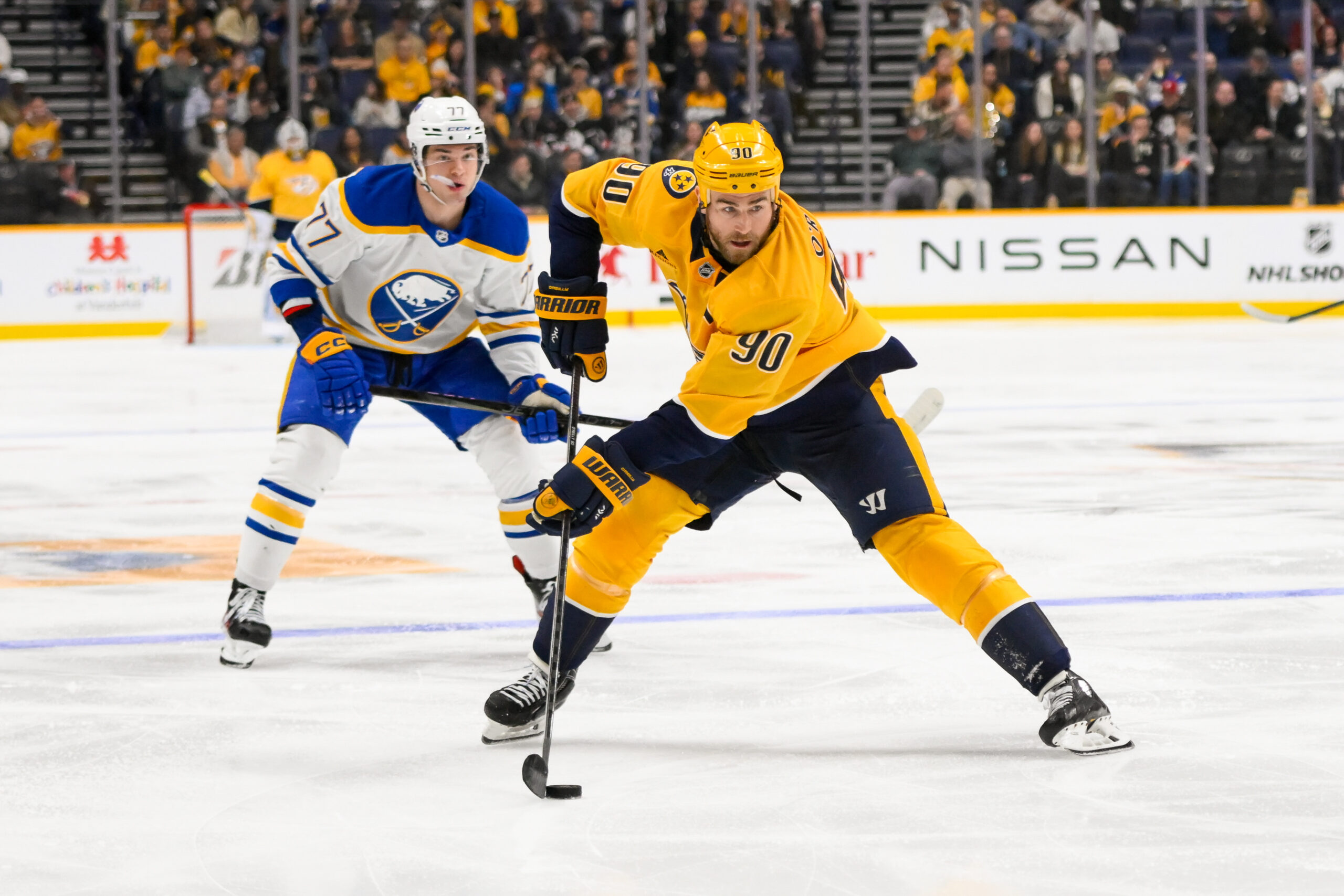 Feb 8, 2025; Nashville, Tennessee, USA;  Nashville Predators center Ryan O'Reilly (90) skates with the puck against the Buffalo Sabres during the third period at Bridgestone Arena. Mandatory Credit: Steve Roberts-Imagn Images
