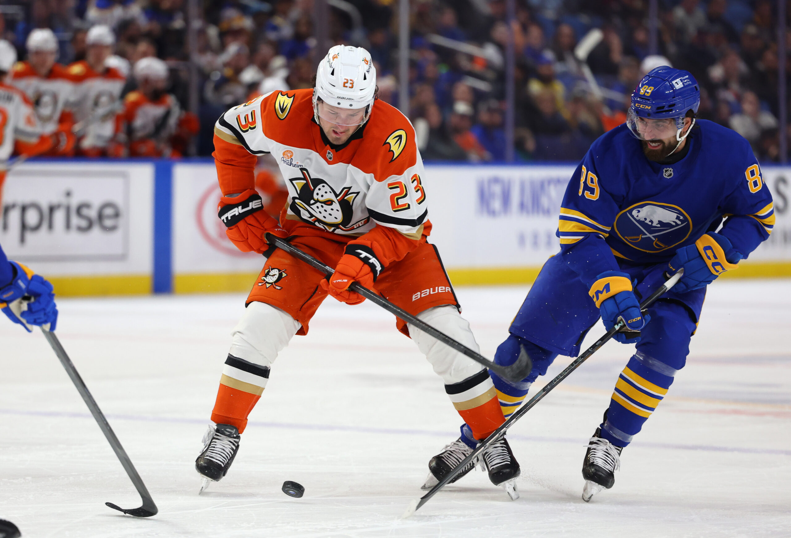Feb 25, 2025; Buffalo, New York, USA;  Anaheim Ducks center Mason McTavish (23) and Buffalo Sabres right wing Alex Tuch (89) go after a loose puck during the first period at KeyBank Center. Mandatory Credit: Timothy T. Ludwig-Imagn Images