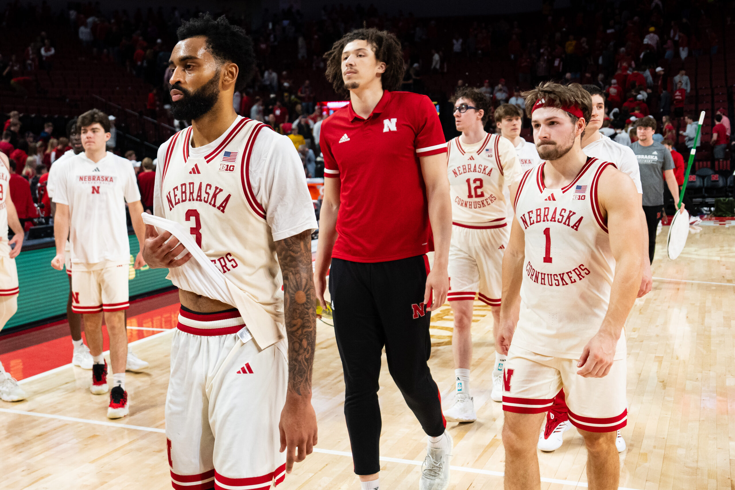 Mar 9, 2025; Lincoln, Nebraska, USA; Nebraska Cornhuskers guard Brice Williams (3), guard Sam Hoiberg (1), center Braxton Meah (red polo) and guard Gavin Griffiths (12) walk off the court after falling to the Iowa Hawkeyes at Pinnacle Bank Arena. Mandatory Credit: Dylan Widger-Imagn Images