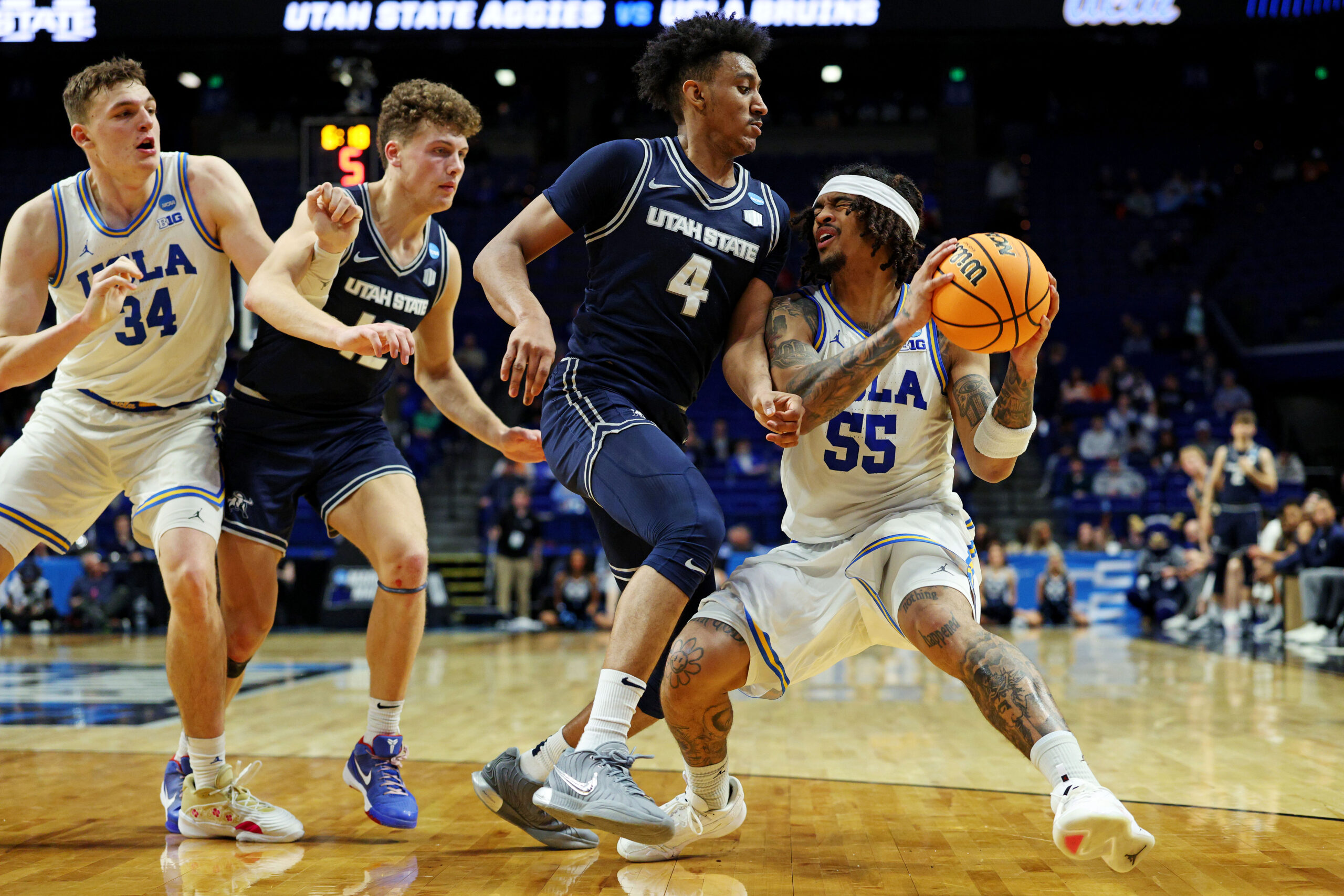 Mar 20, 2025; Lexington, KY, USA;  UCLA Bruins guard Skyy Clark (55) drives to the basket against Utah State Aggies guard Ian Martinez (4) during the second half in the first round of the NCAA Tournament at Rupp Arena. Mandatory Credit: Jordan Prather-Imagn Images